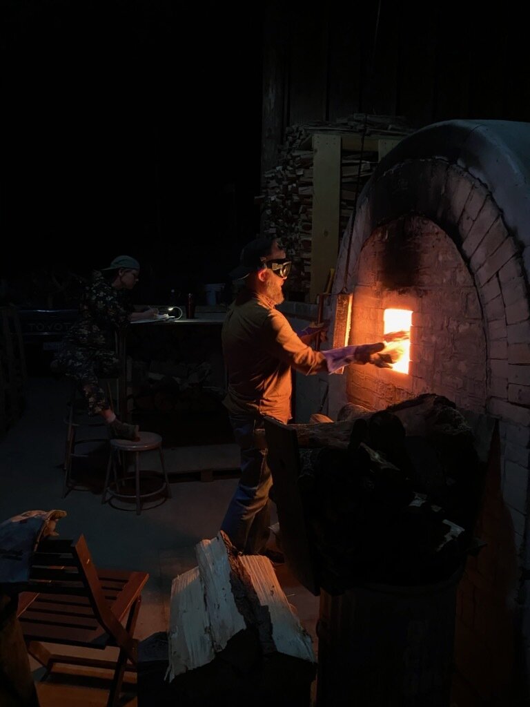 Stoking wood in the firebox of an anagama kiln