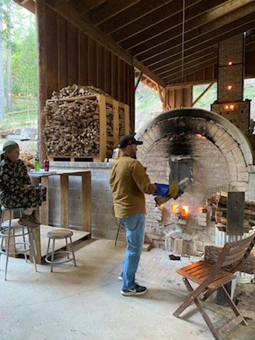 Stoking wood in the fire box of an anagama kiln