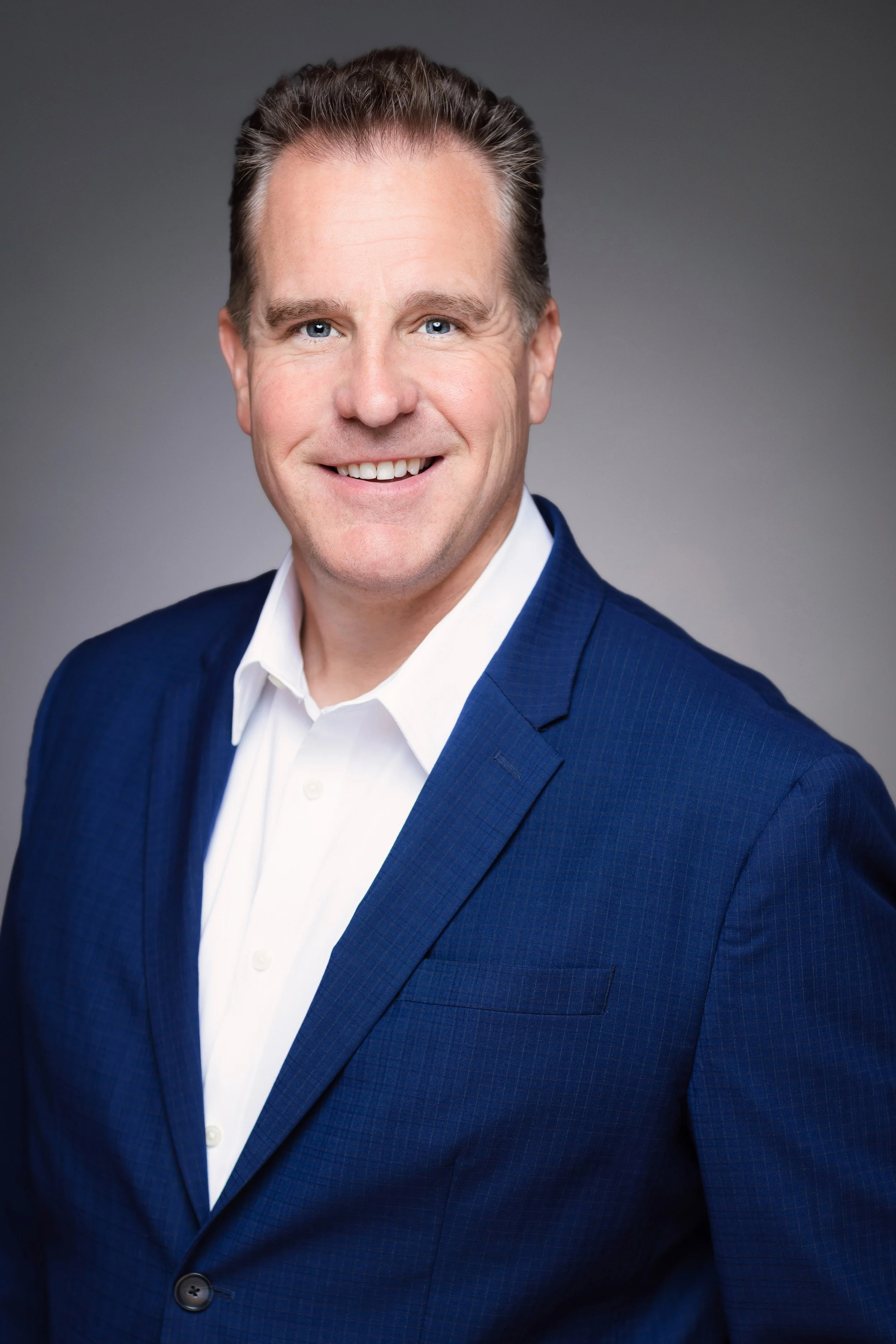 business headshot of a man smiling looking at the camera