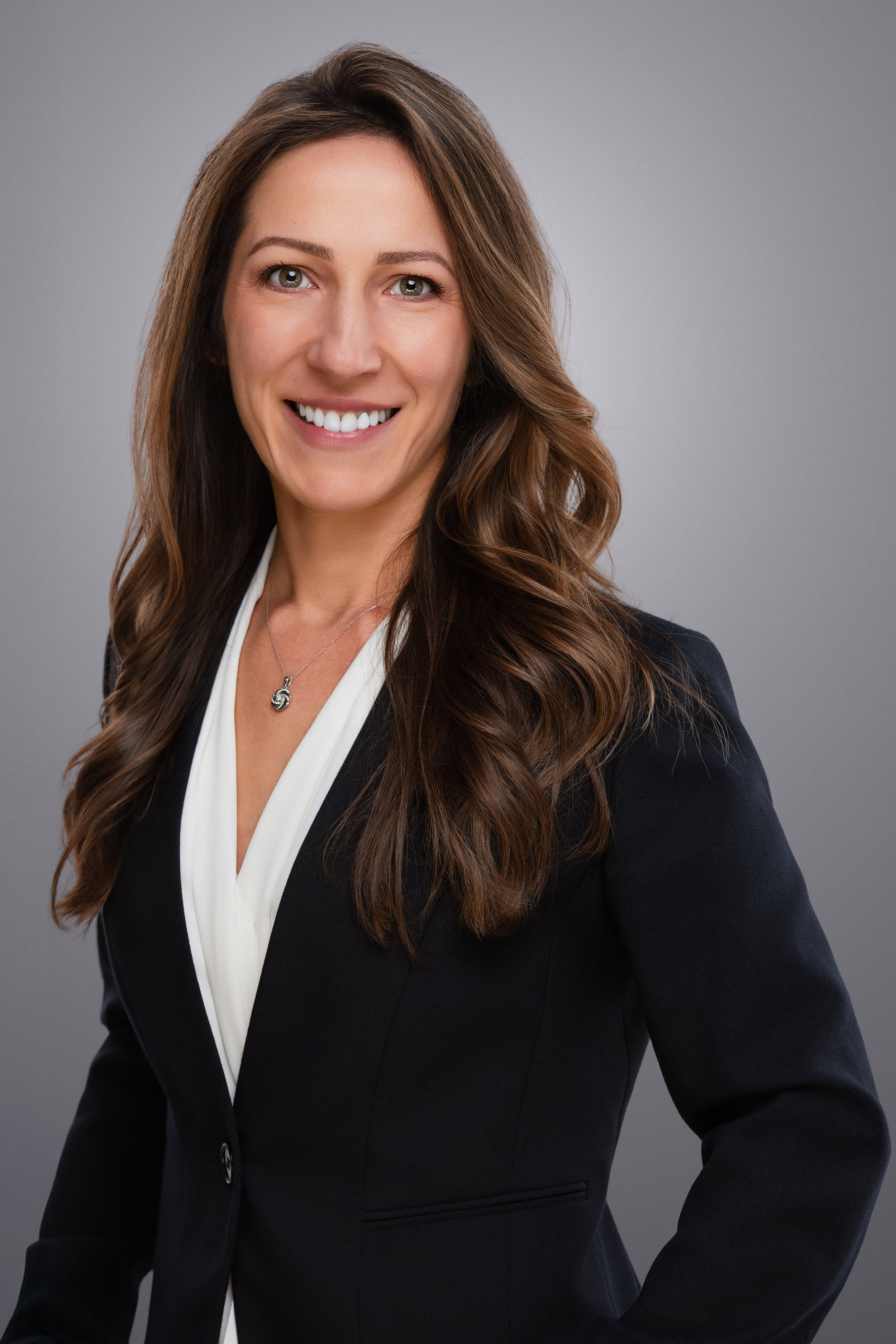 business headshot of a woman with brown hair wearing a suit smiling looking at the camera