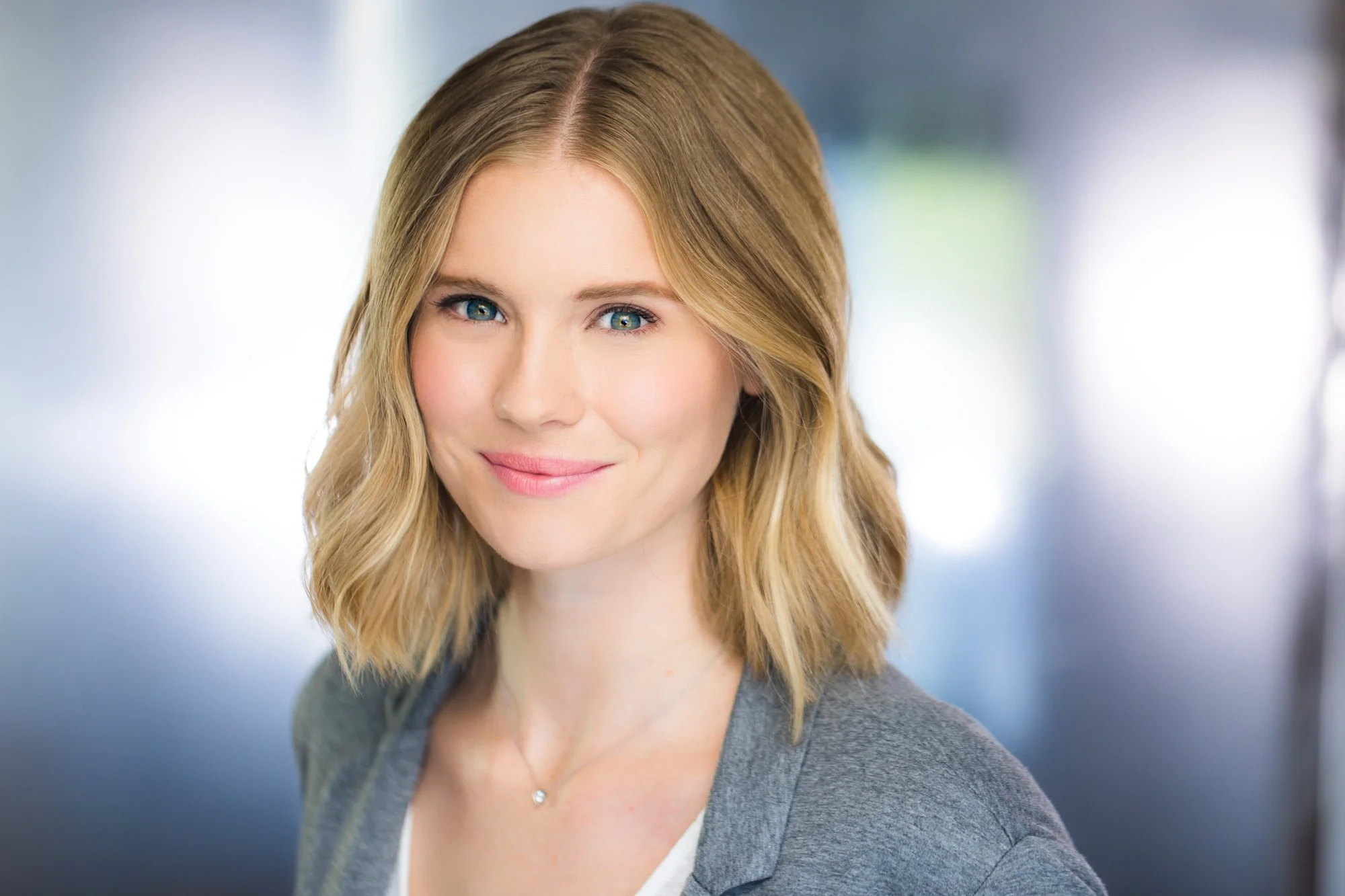 Executive headshot of a woman in a suit against a softly blurred office background