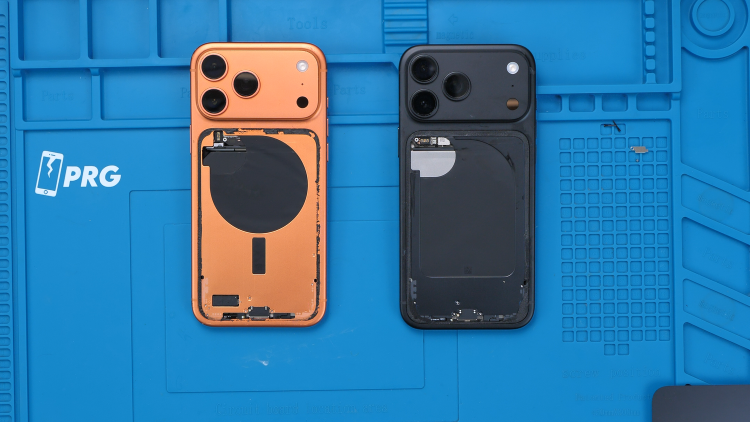 Orange and black iPhones side by side with their back glass removed.