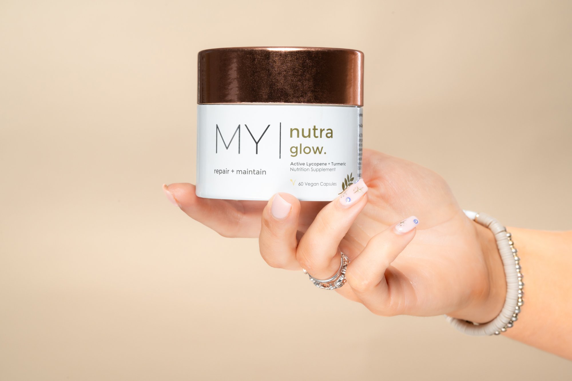 Female model / influencer hand holding MY Visage My Nutra Glow nutrition supplement product photograph.