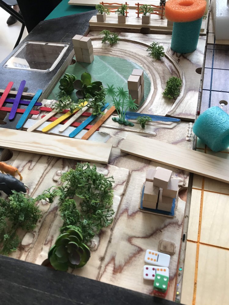 Students building a miniature urban city model during a design and STEM workshop