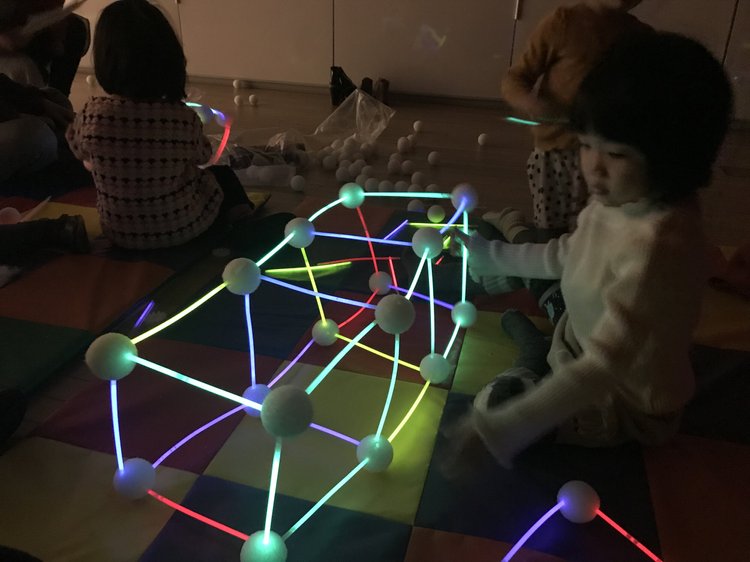 Students exploring glow sticks and geometry during a Glow-in-the-Dark Math STEM workshop
