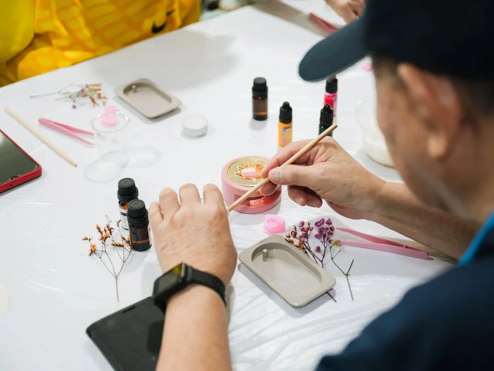 Senior crafting herbal product in Singapore wellness workshop