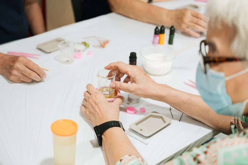 Participant making herbal balm in a hands-on wellness workshop