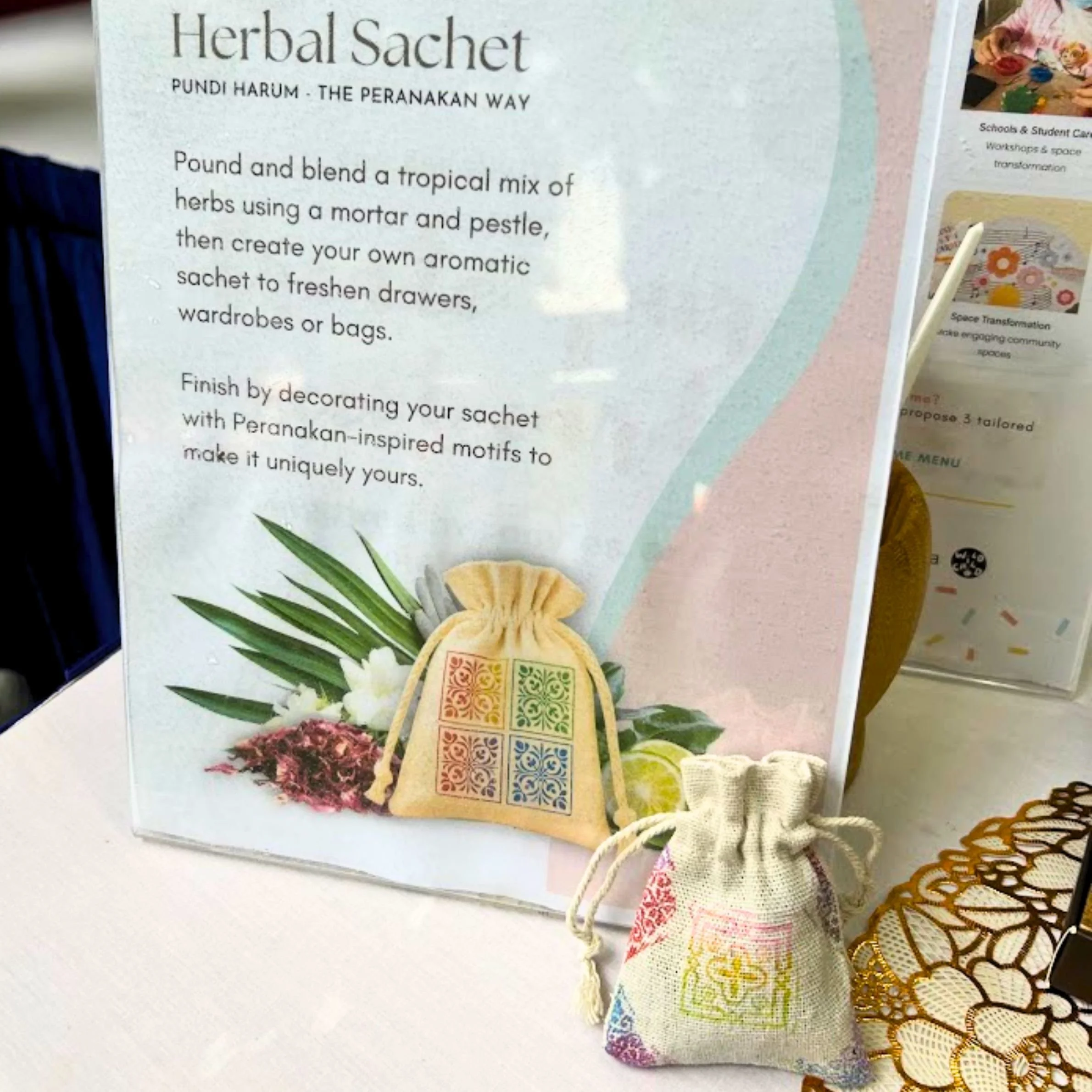 Participants making herbal sachets inspired by Peranakan motifs and herbs at a heritage festival in Singapore.