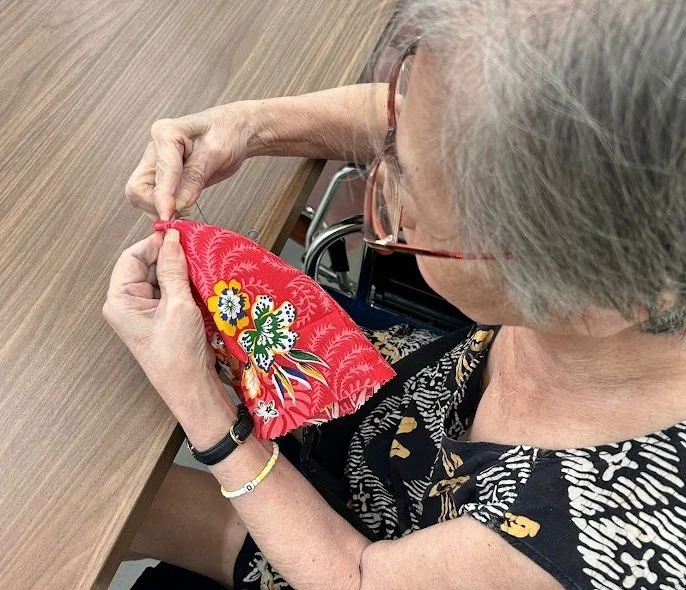 Senior making batik herbal heat pack during hands-on workshop