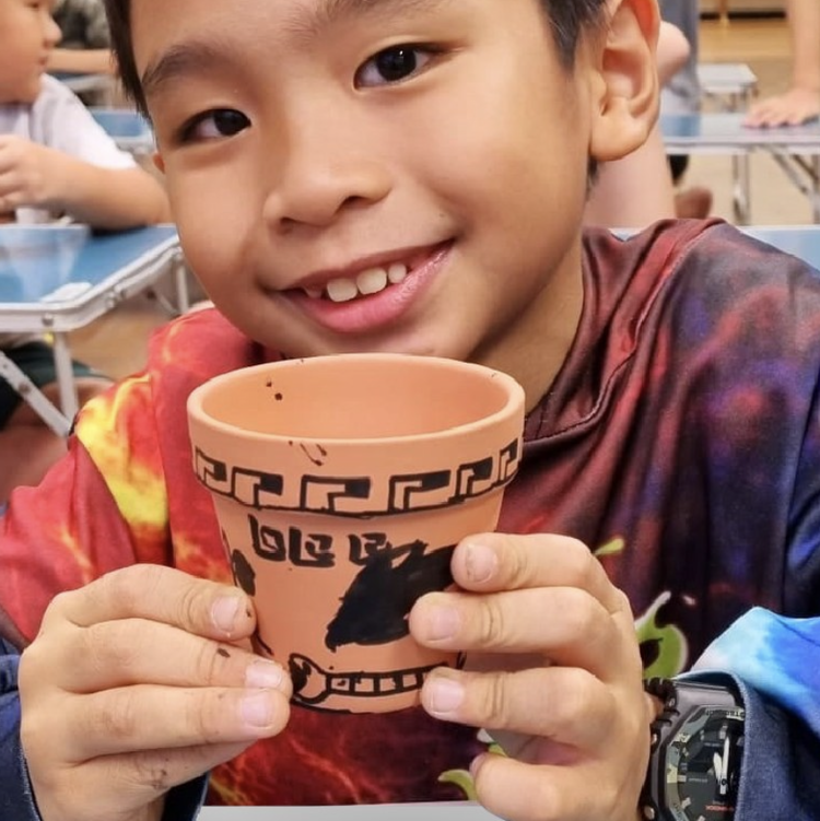 Student holding an ancient civilisation inspired art project during a school art workshop