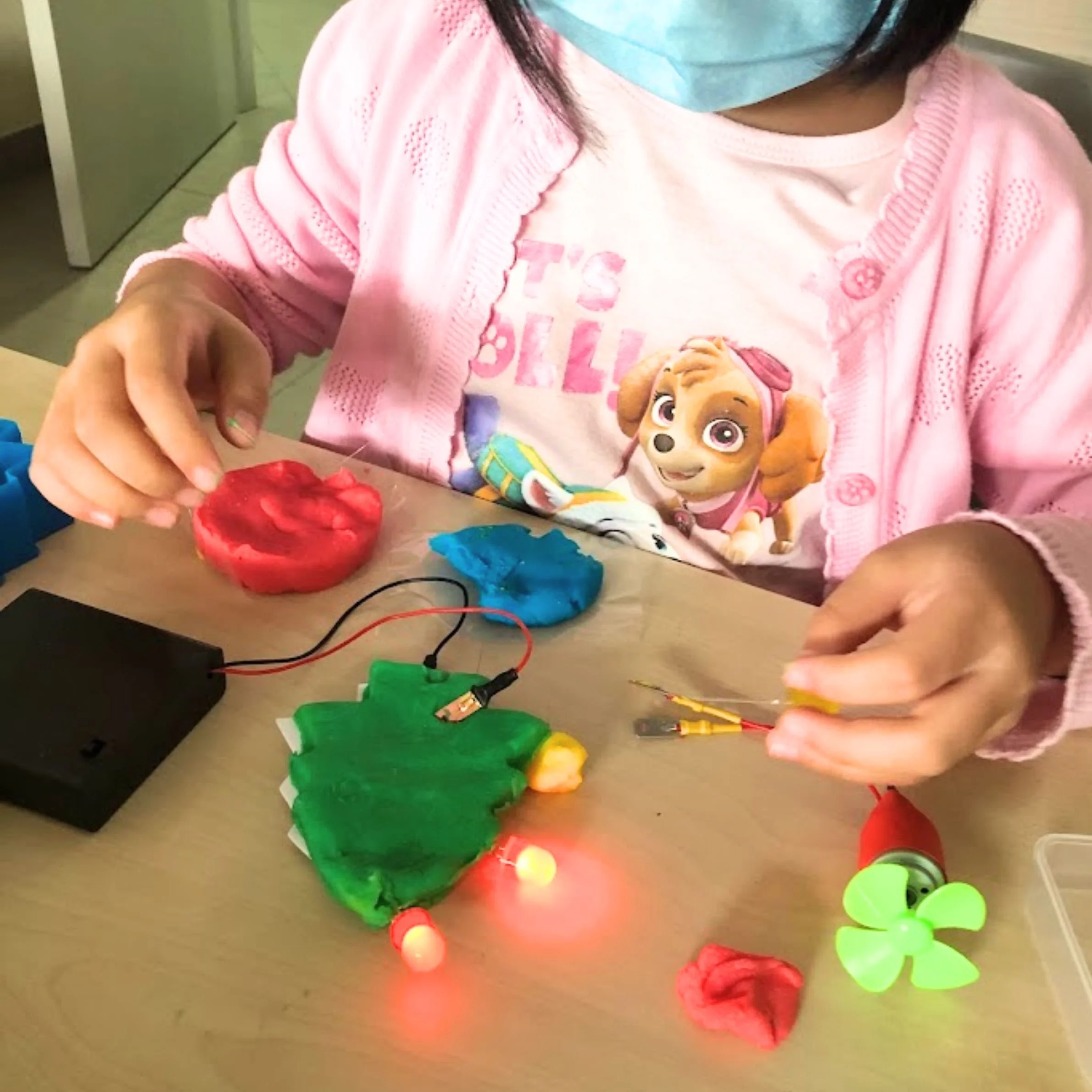Children participating in hands-on activities at an RN holiday science camp in Singapore.