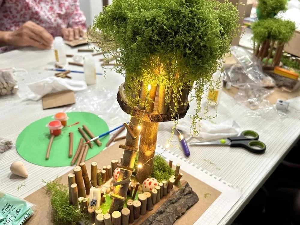 Senior making craft treehouse in Singapore workshop