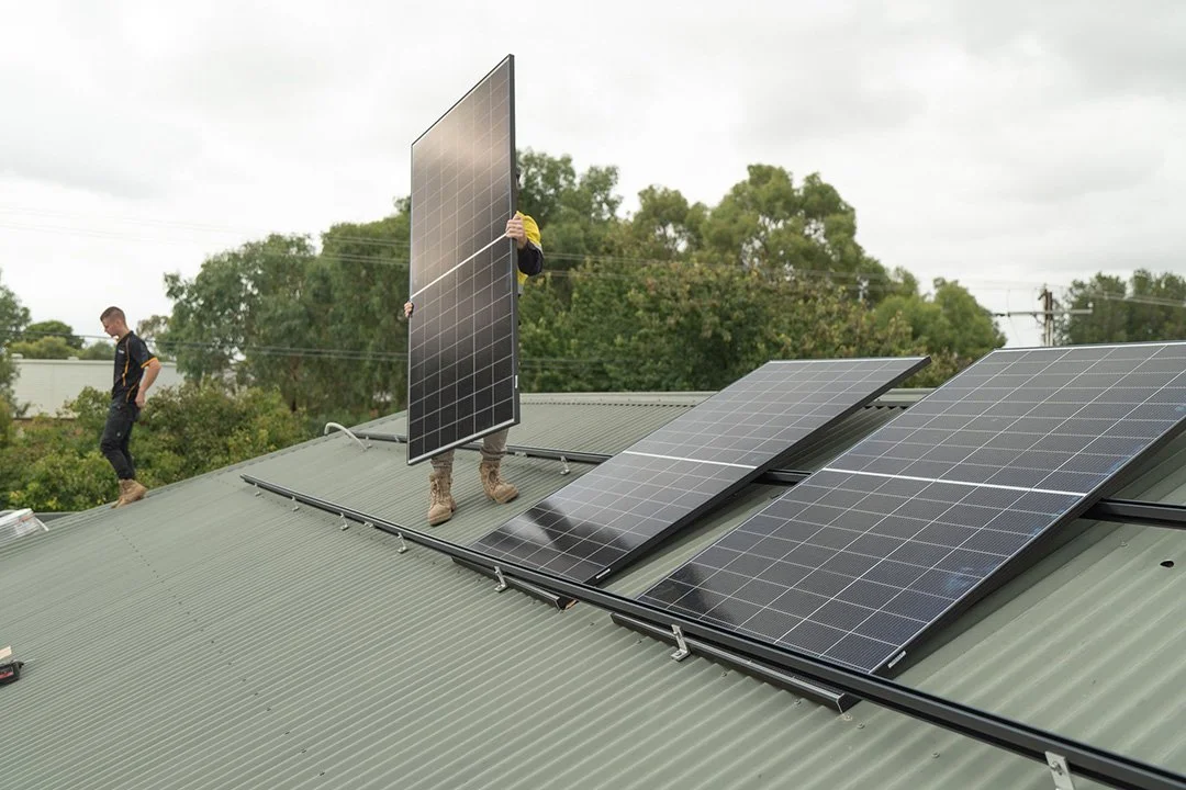 Two workers installing solar panel