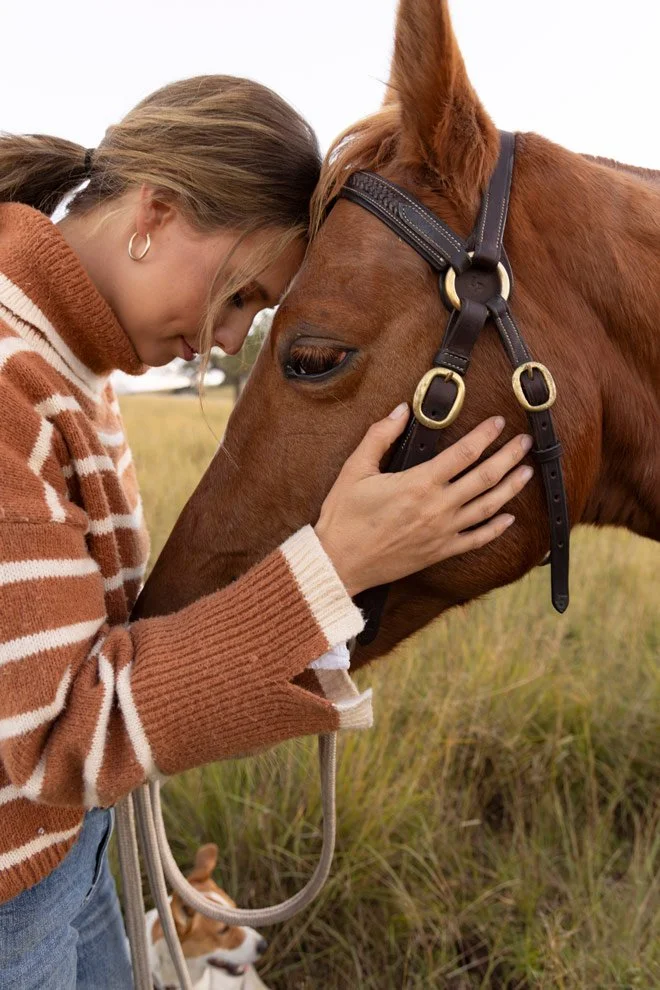 Personal brand photography, Sophie of Reins to Resilience with head resting against horse in golden hour light, Candelo Bega Valley NSW