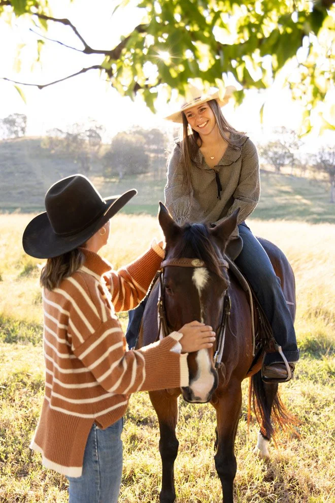 Brand photography Bega Valley, Sophie of Reins to Resilience supporting teenage participant on horseback in golden afternoon light, Candelo NSW