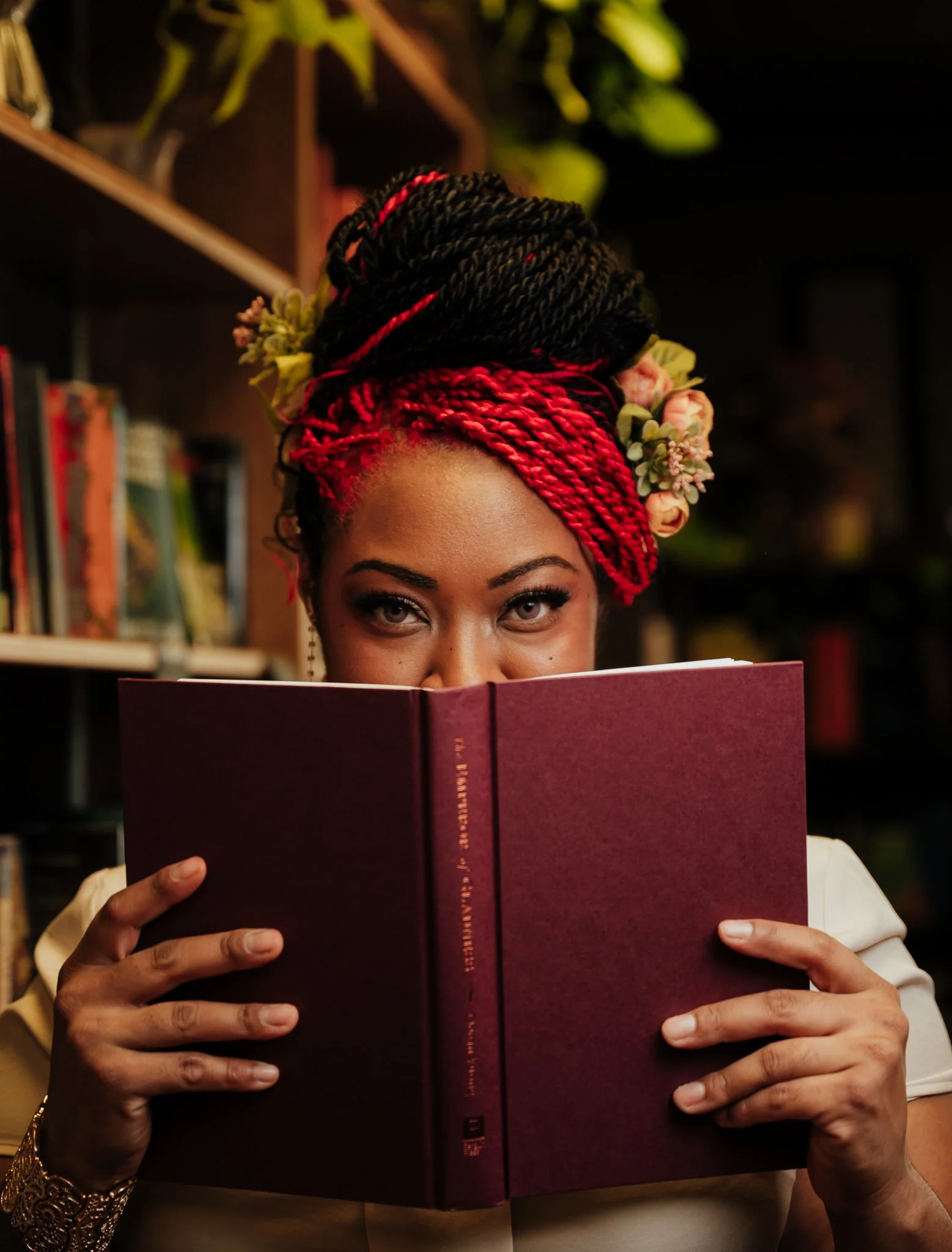 woman peeks over top of a book