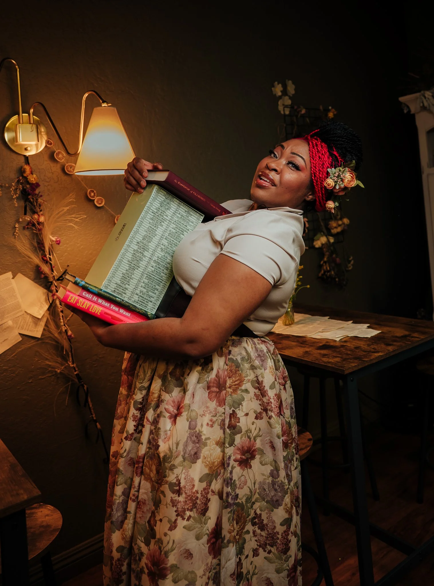 woman holds tower of books