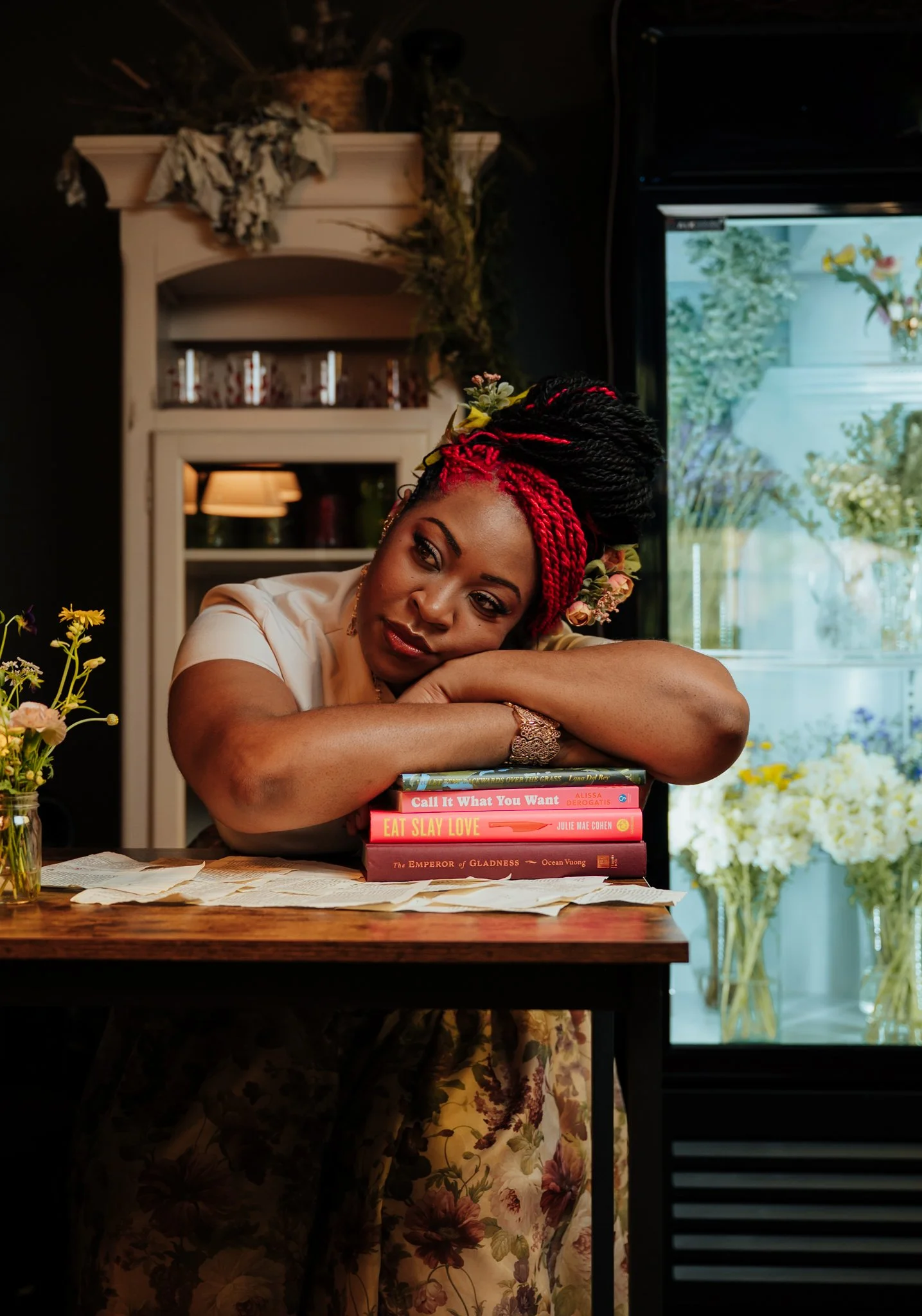 woman rests her head on stack of books