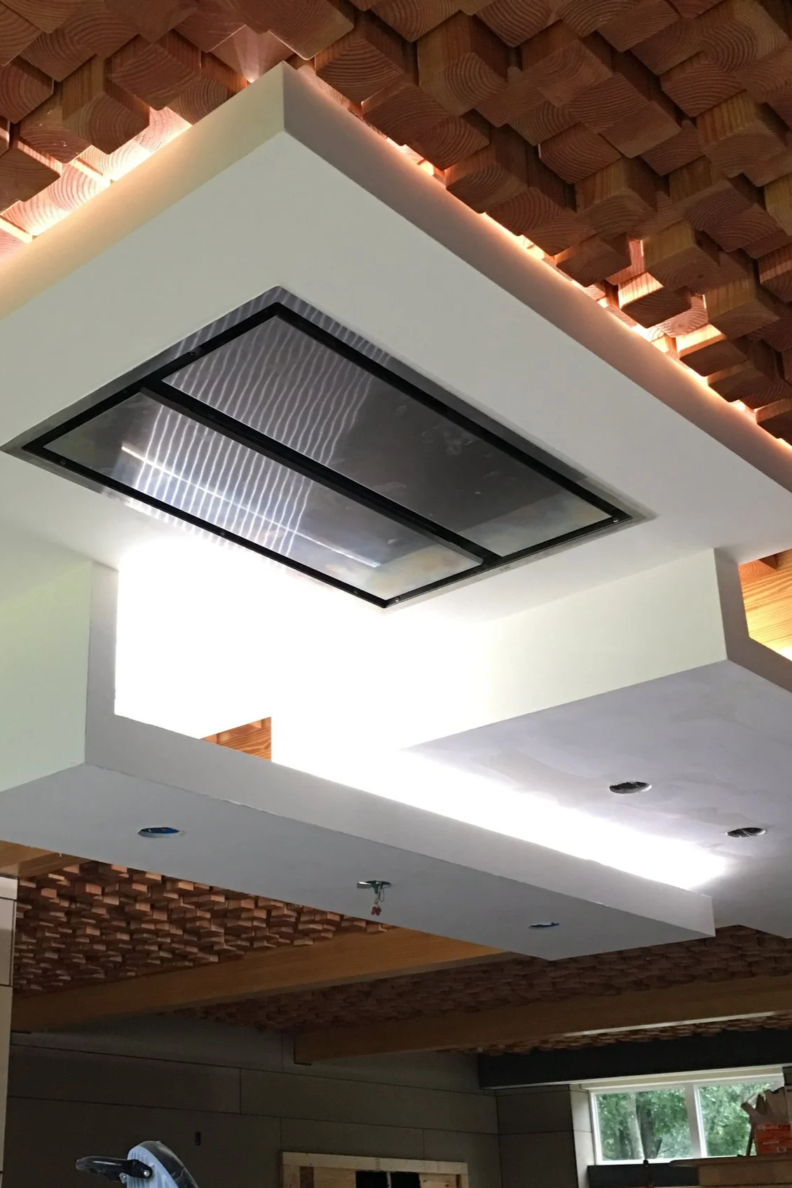 Interior ceiling with modern heating, ventilation, and air conditioning system, and decorative wooden panels.