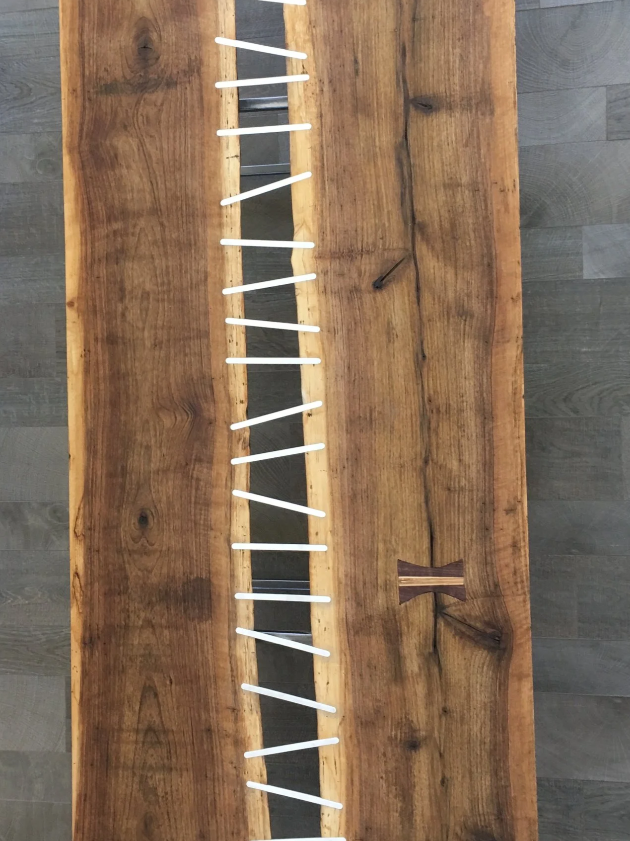 A wooden table with a row of white and black glow sticks arranged on top, some of which are tilted or broken.