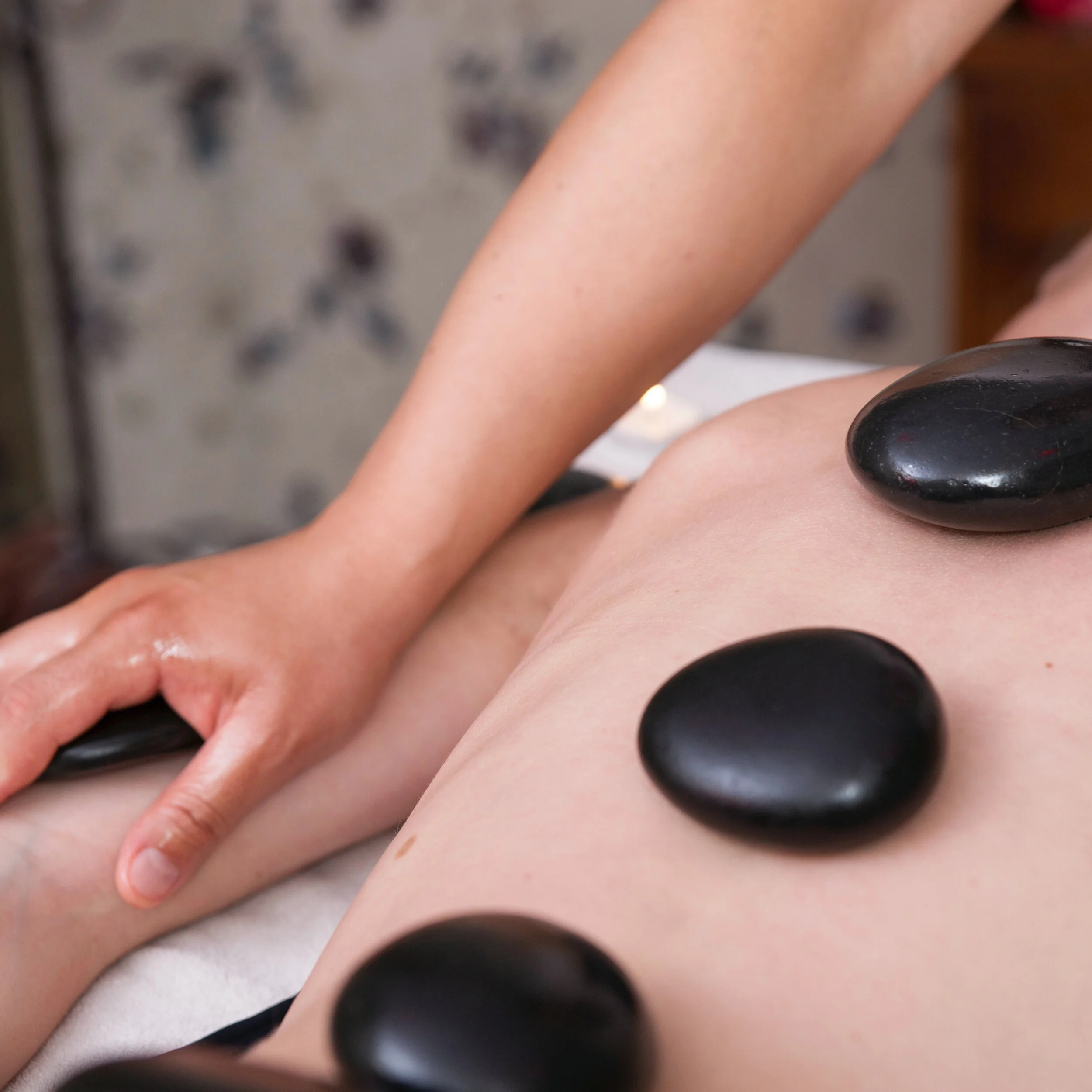 Hot stone massage treatment in Mortimer using heated stones to relax muscles