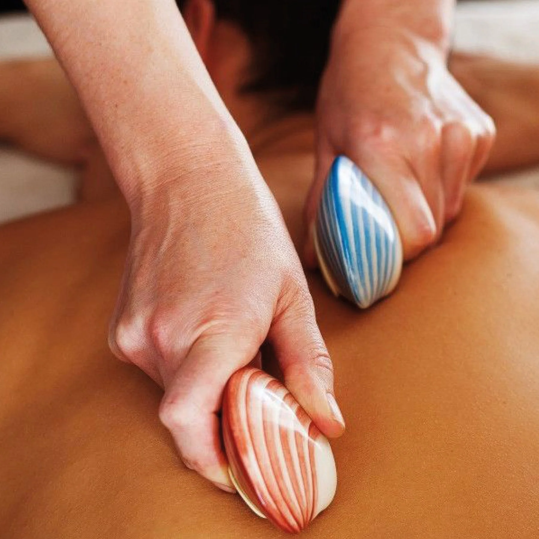 Lava shell massage treatment in Mortimer using heated shells to relax muscles.
