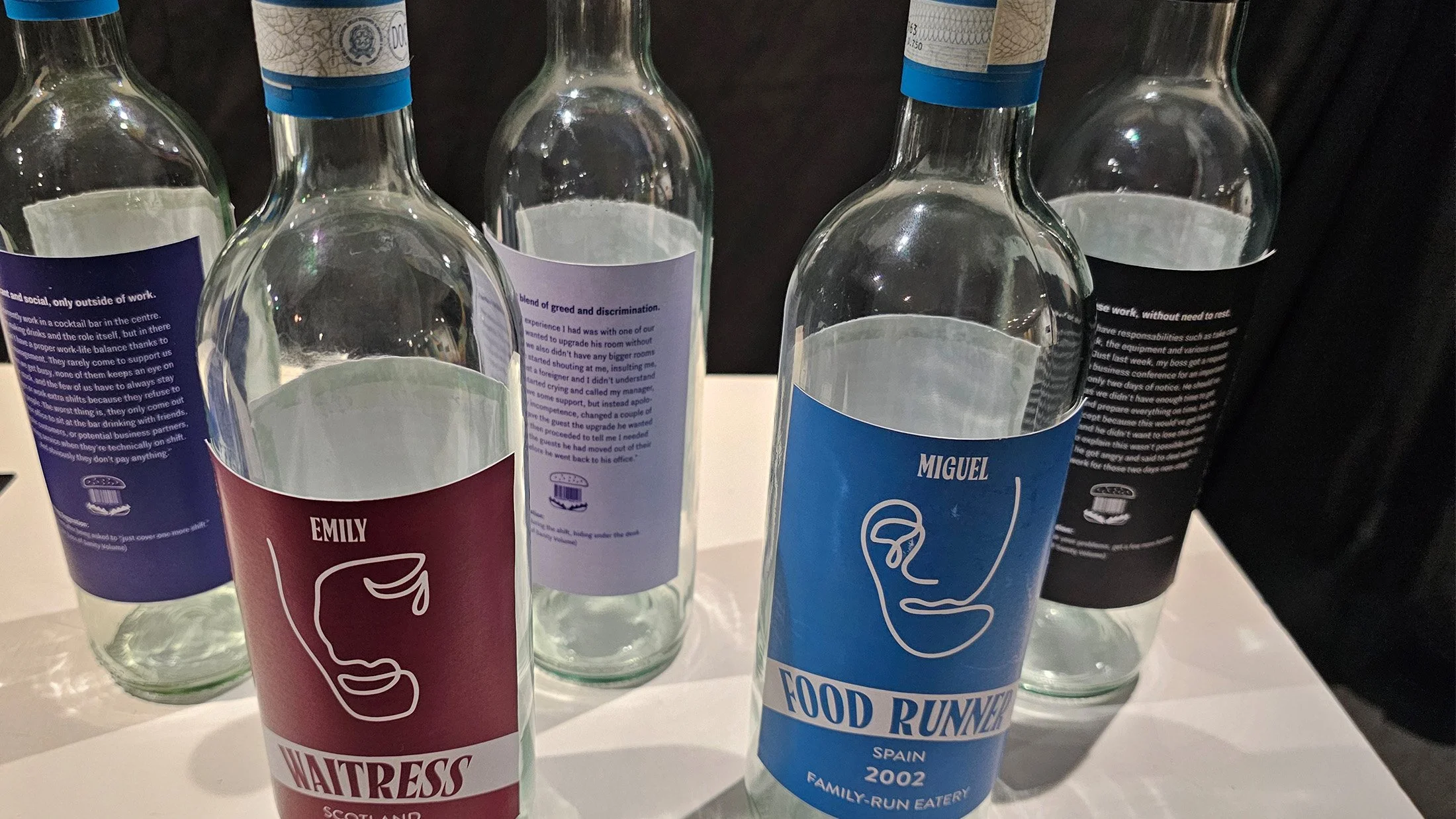 Wine bottles, each with a different label telling someone’s story.