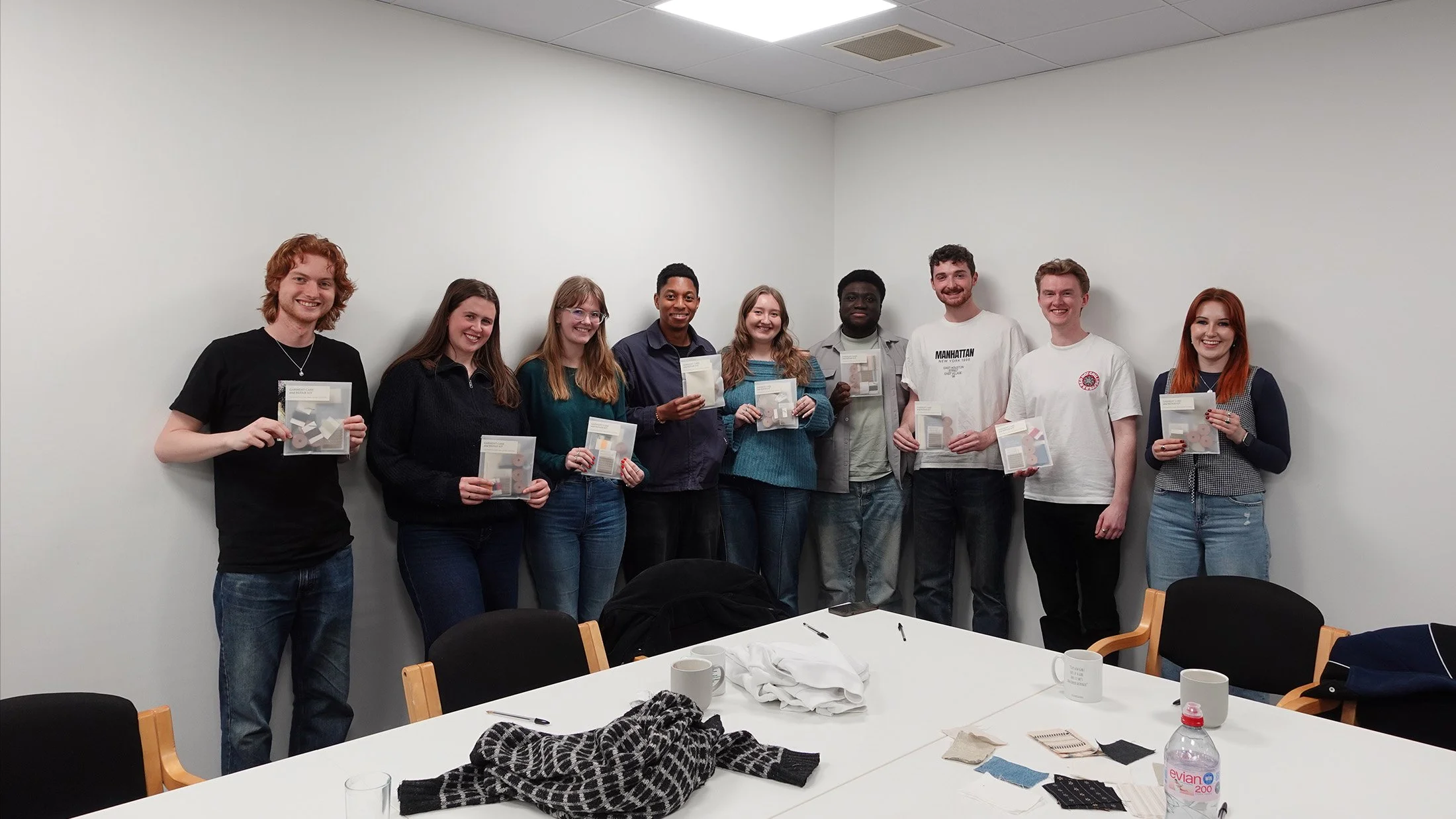 Workshop participants holding their completed garment care and repair kits.
