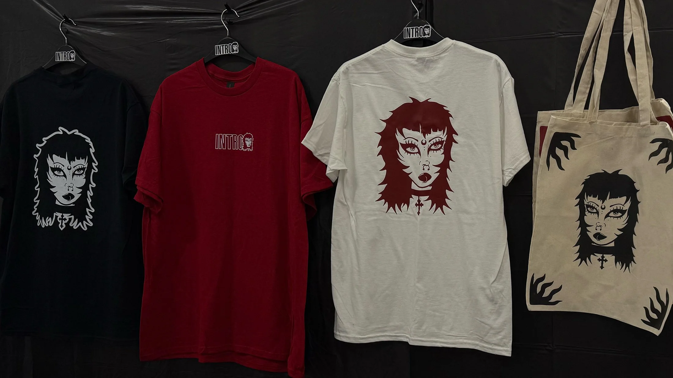T-shirts and tote bags with INTRO's logo and Trad Goth illustration.