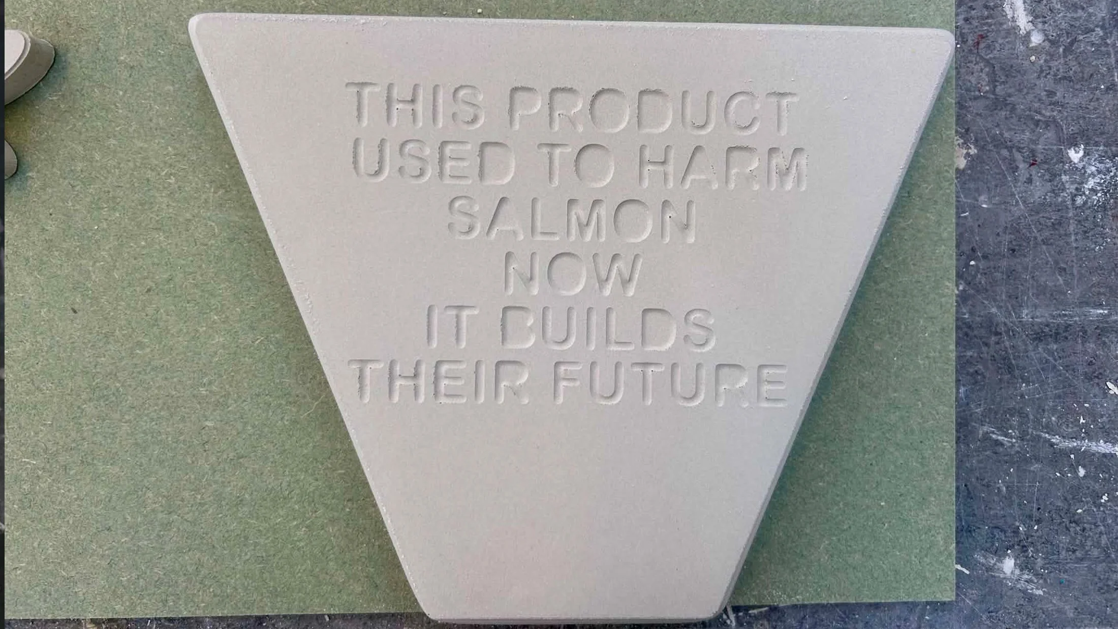 Plaster tile prototype featuring embossed lettering to test surface clarity and material finish.