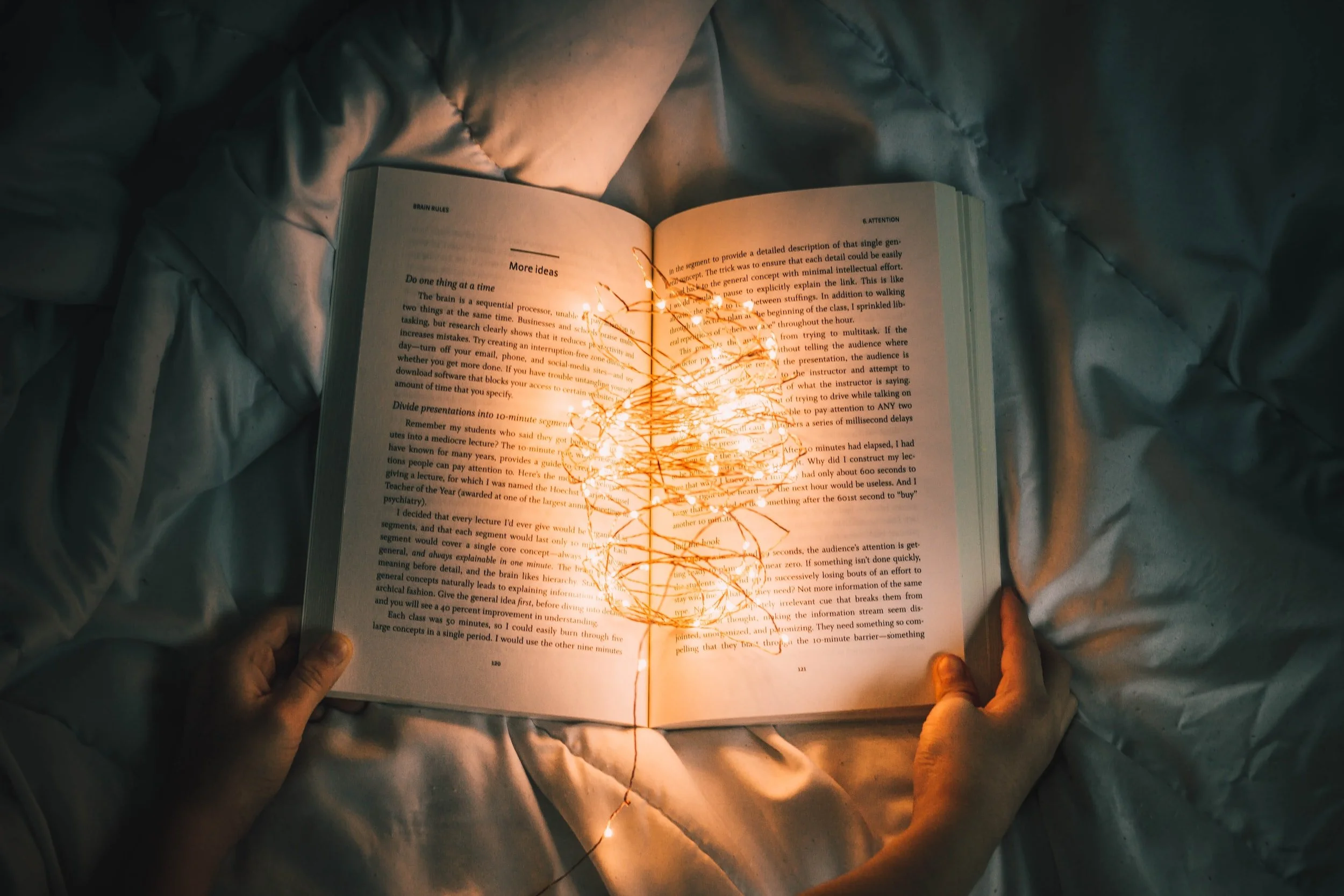 book open with lights on it laying on a blanket
