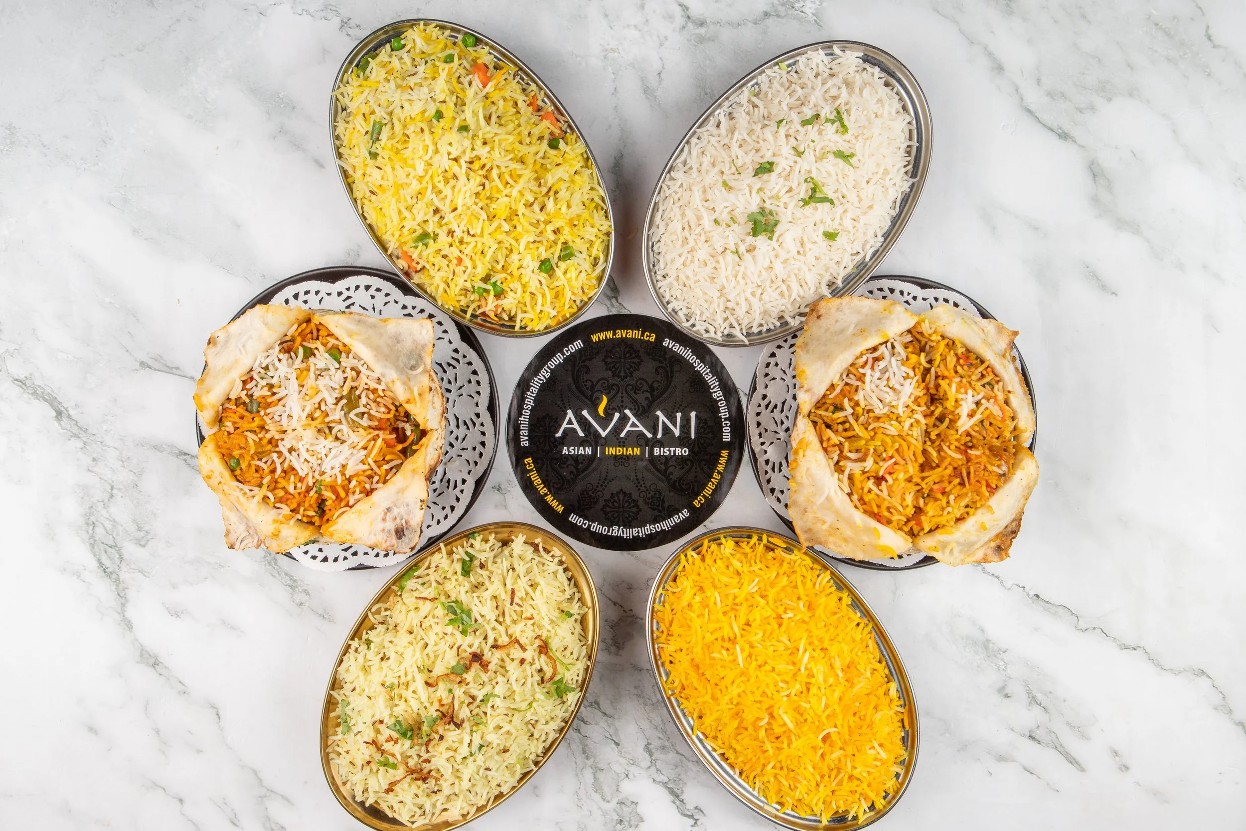 An elegant spread of fragrant basmati rice dishes, featuring classic biryanis and delicately spiced rice varieties. Each bowl highlights vibrant colors, fluffy textures, and authentic Indian aromas.