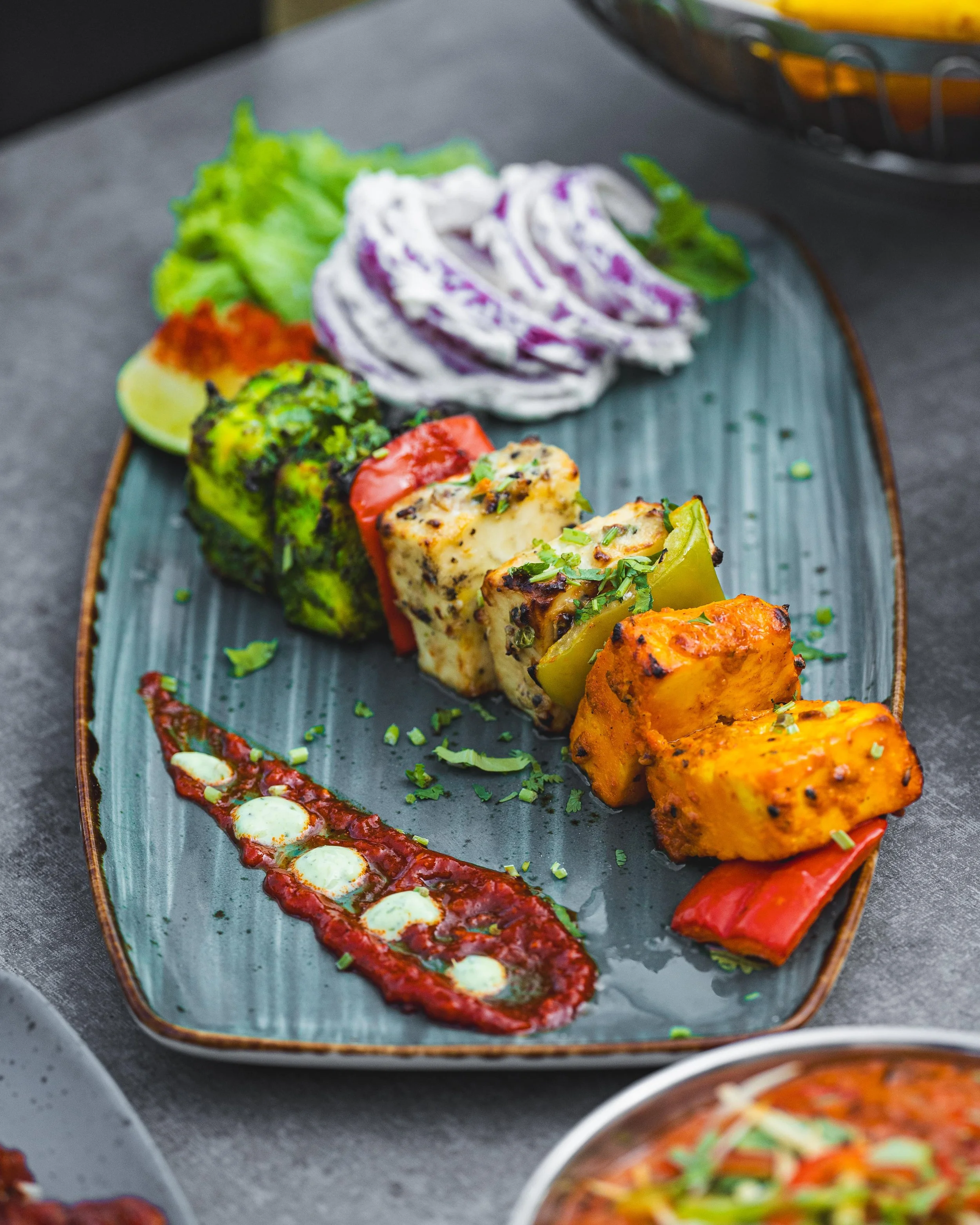 Zaika NCR Paneer Sampler: Chef's selection tandoor grilled paneer, including achari, hariyali, and kali mirch flavours served beautifully. 