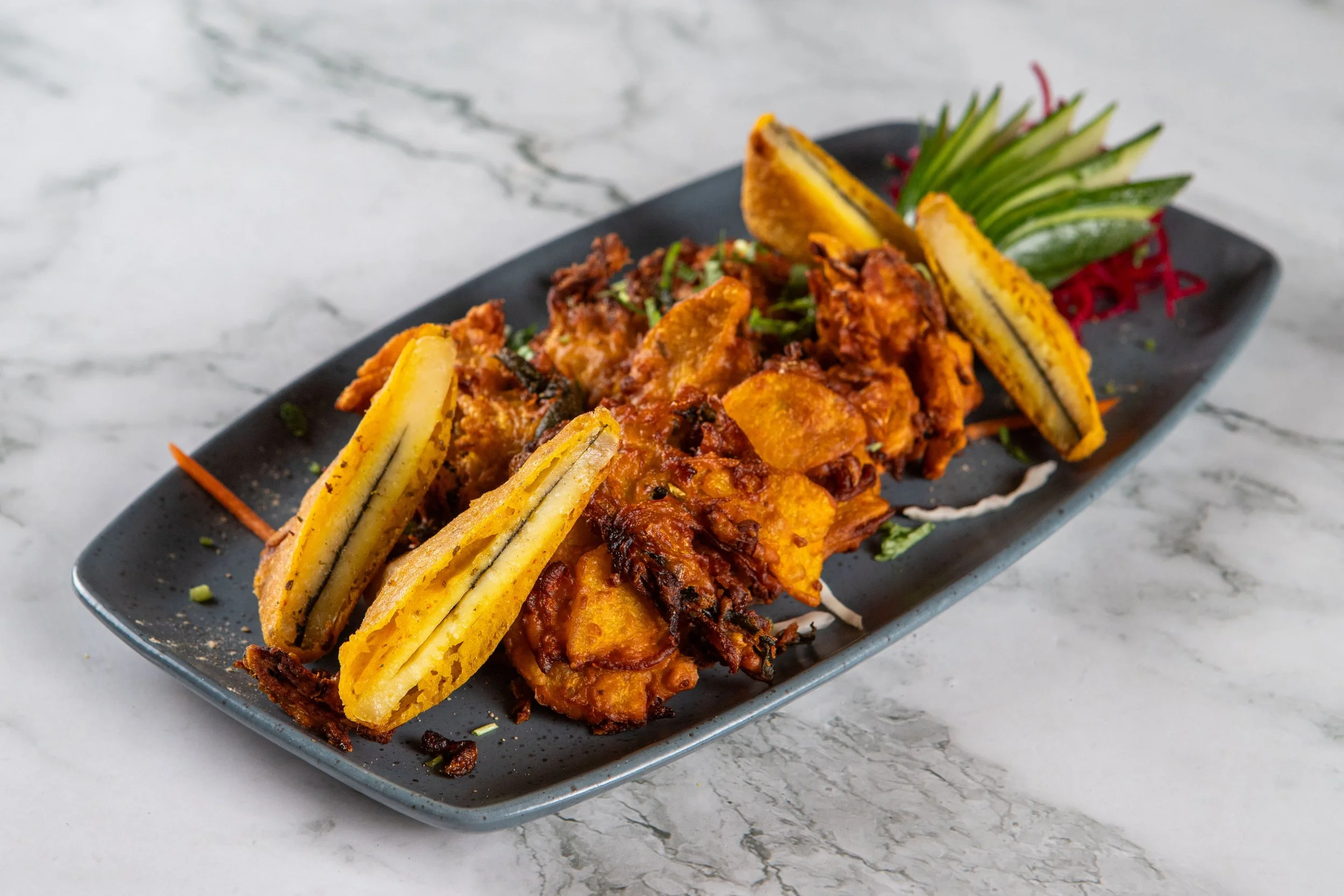 Veg Pakora: A tasty combination of paneer and veg fritters battered with chickpea flour.