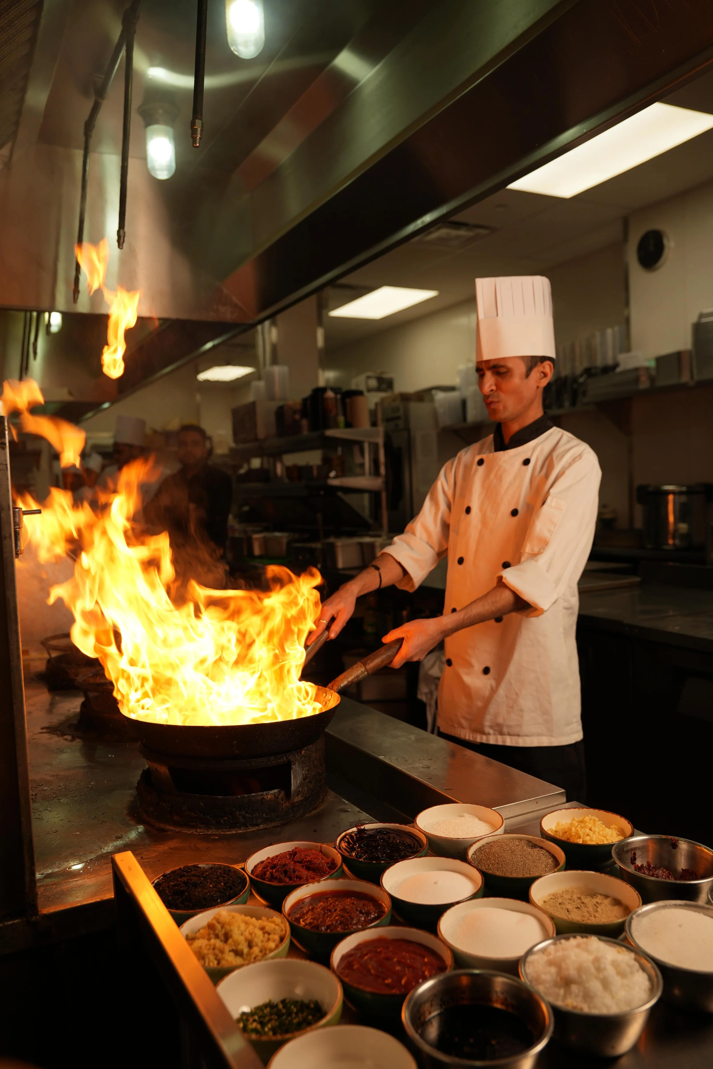 A chef in action, bringing bold flavours to life with live-fire cooking in our professional kitchen. Every dish is crafted with passion, precision and authentic technique. 