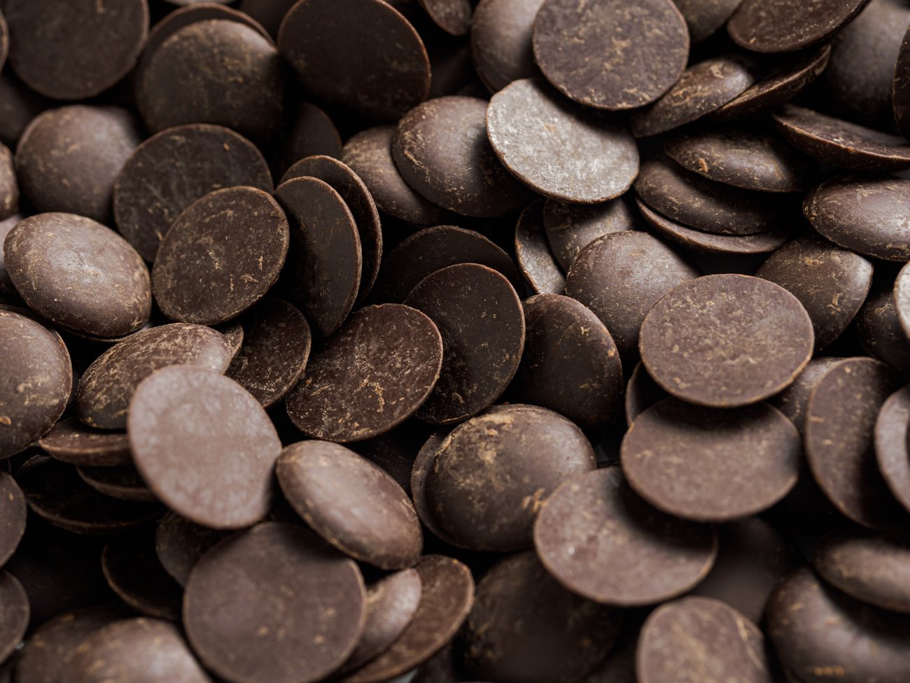Close-up of numerous dark chocolate chips piled together.
