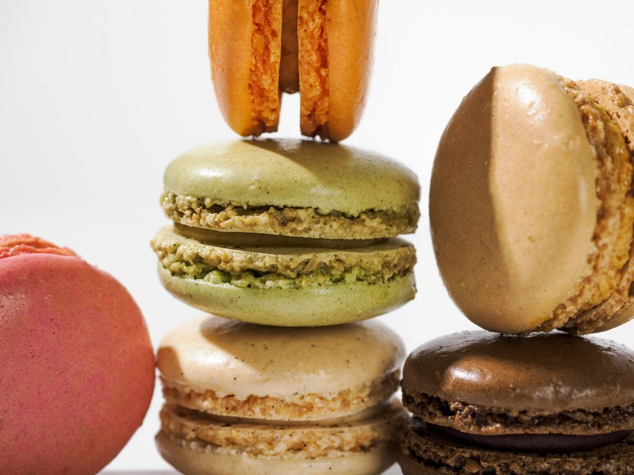 Close-up of colorful macarons stacked and floating in mid-air.