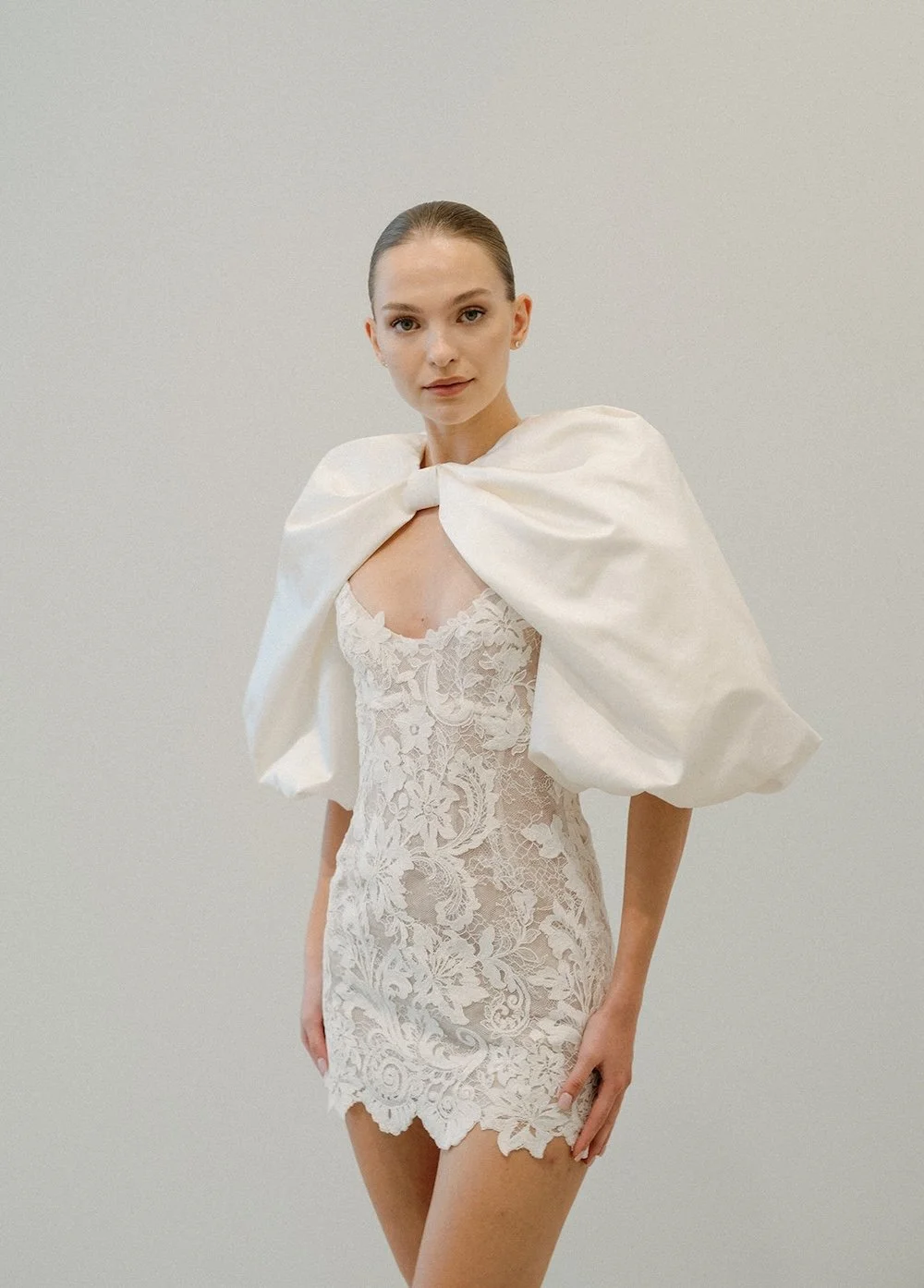 Mini lace dramatic, oversized bow sleeve wedding dress from Fall 2026 New York Bridal Fashion Week, Beth Chapman Styling, Monique Lhullier