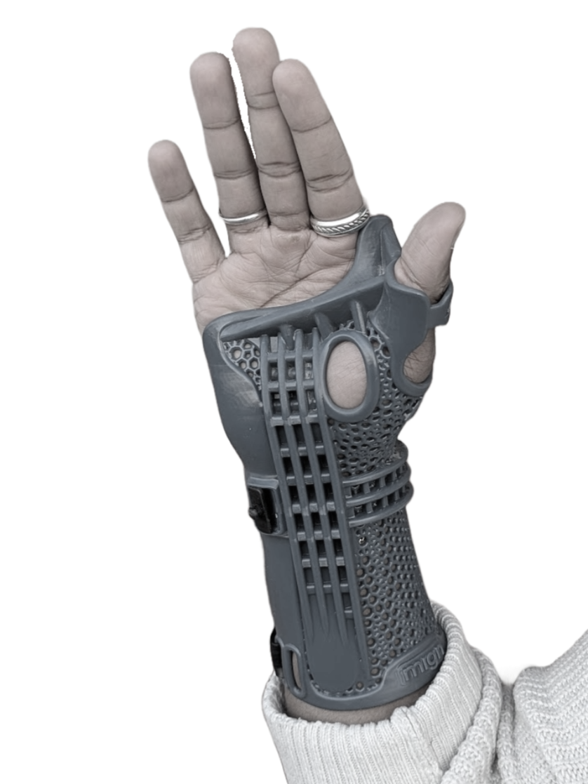 A human hand with rings wearing a gray robotic or prosthetic hand and sleeve, raised with fingers spread apart.