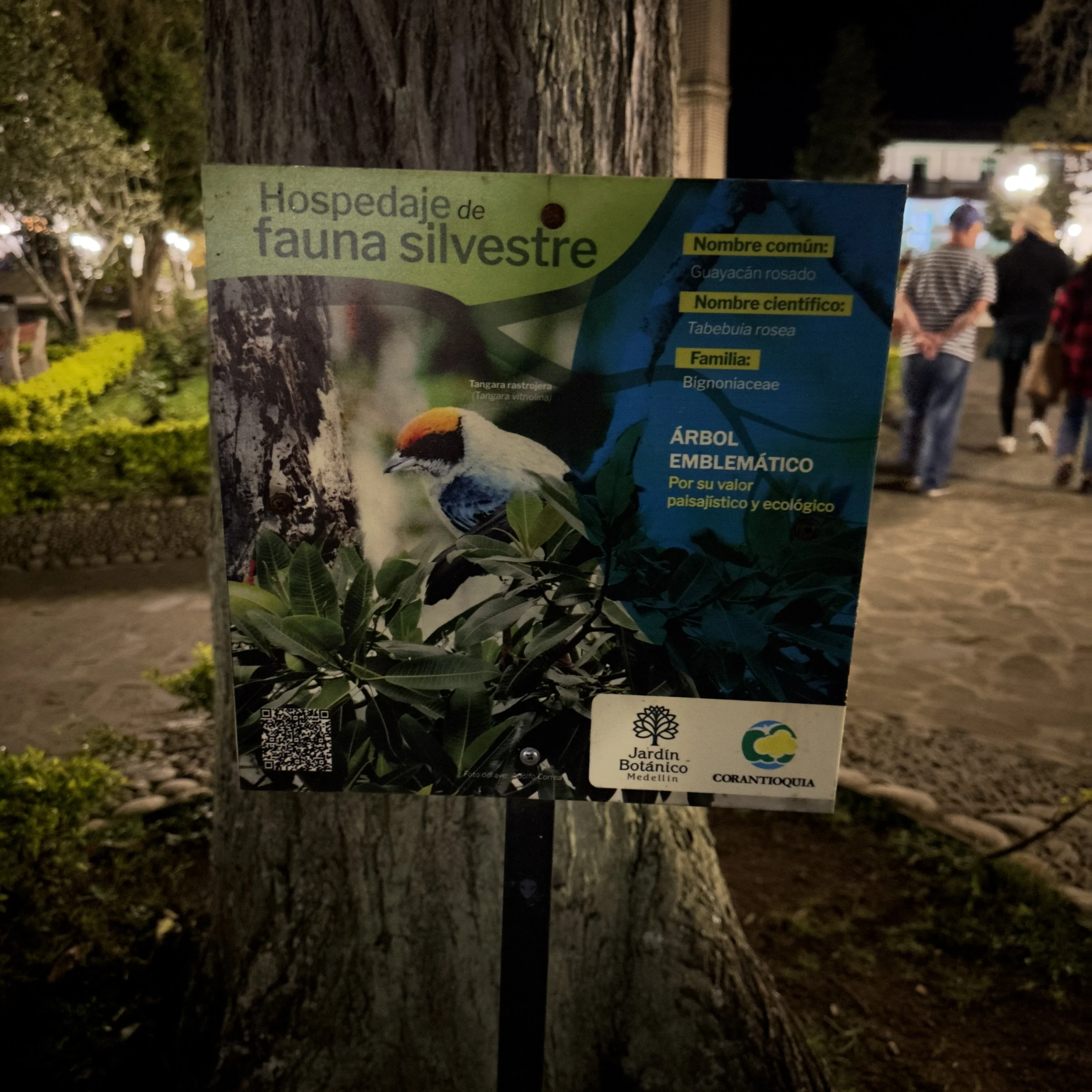 Identification sign for a wild fauna sanctuary, featuring a colorful bird with a yellow, orange, black, and white head perched on a branch, with text in Spanish.