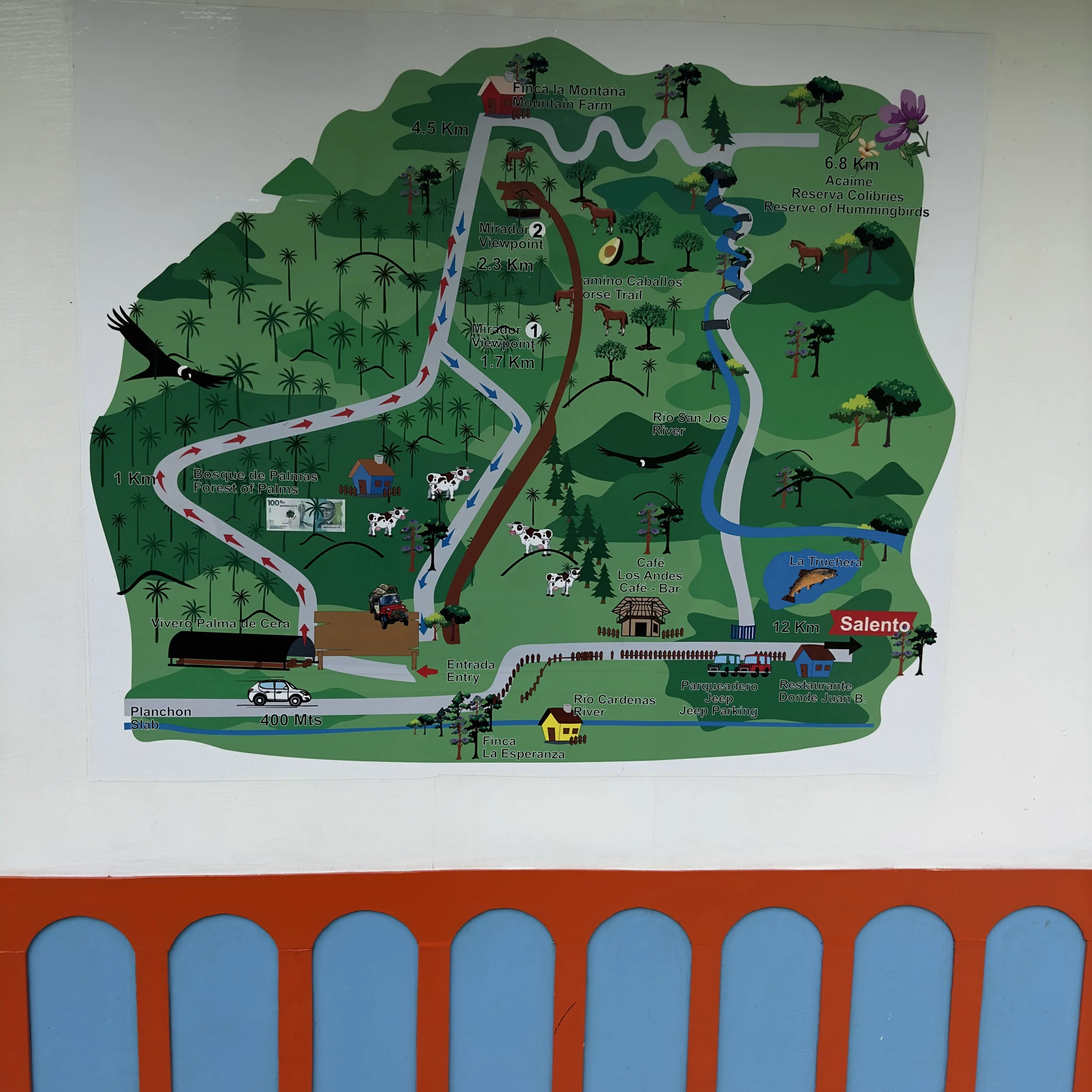 Map of a farm or nature park with trails, viewpoints, river, and various animals like horses, cows, and birds, with labels in Spanish and English.