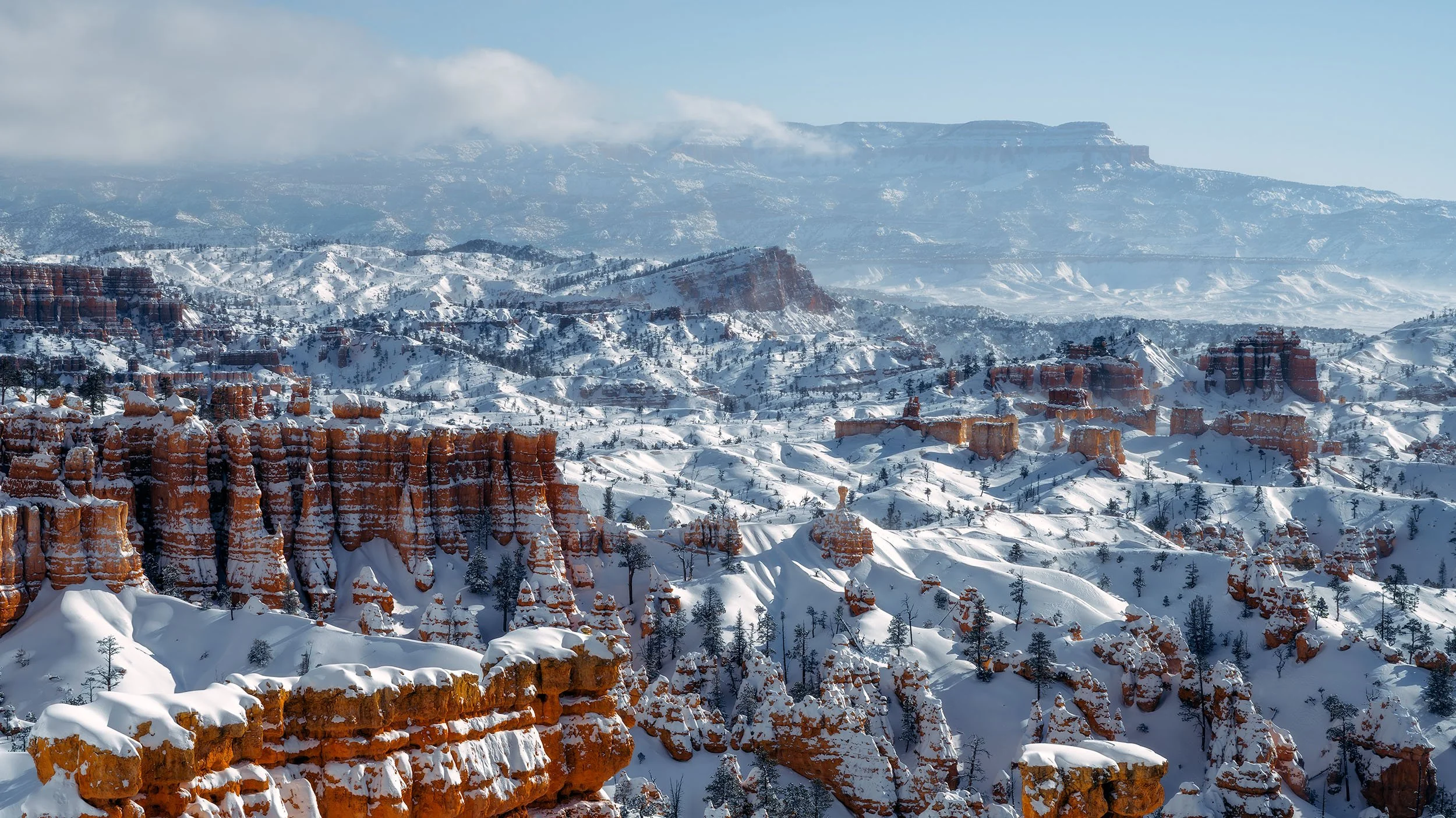 Snow-covered Bryce Canyon with red rock formations.
  Atmospheric, Light, Intimate Landscapes, Cold  