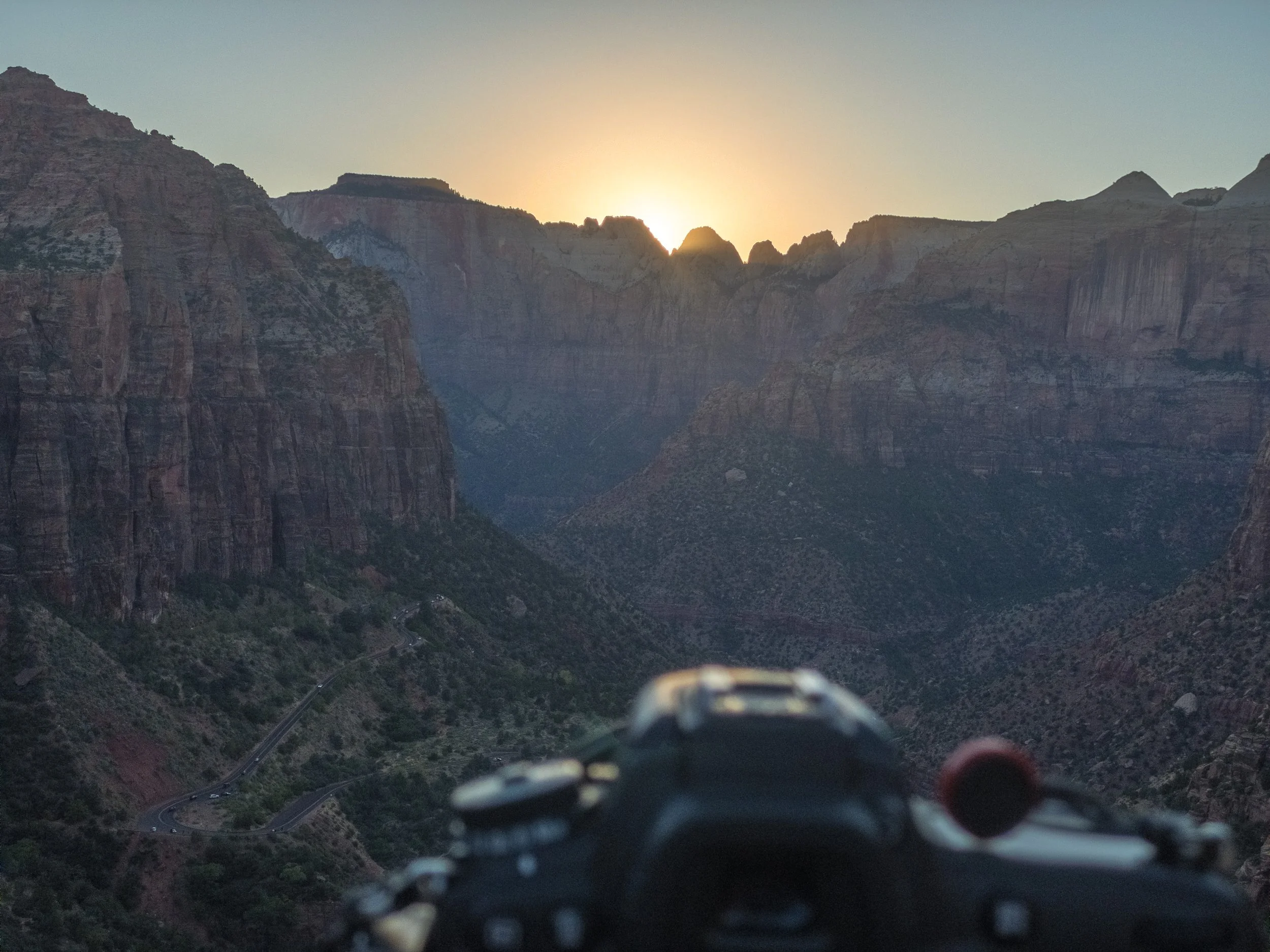 A view of the Grand Canyon at sunset with a camera in the foreground.