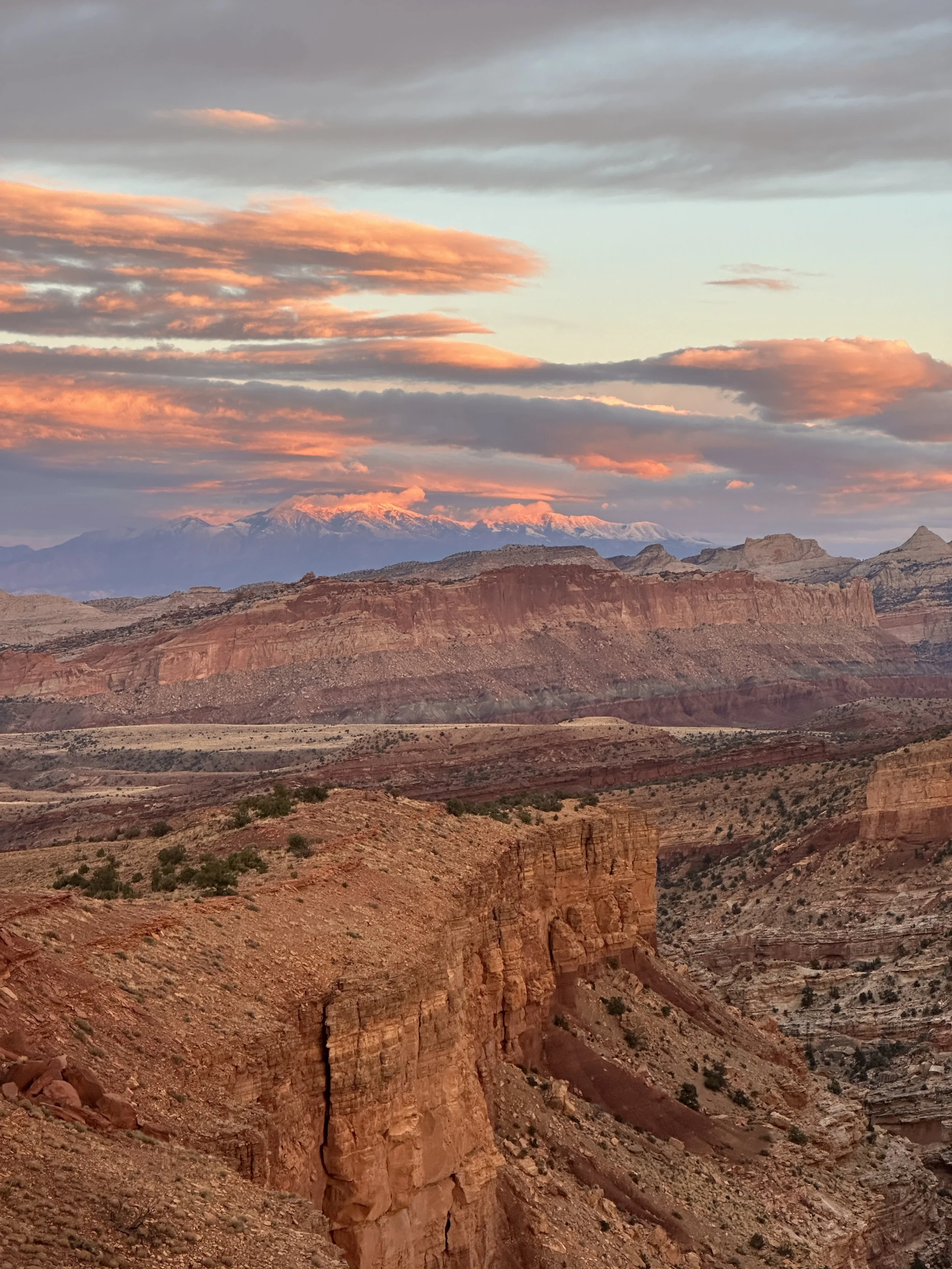 Sunset at Capitol Reef National Park with vibrant clouds and layered red rock cliffs, captured in 2024