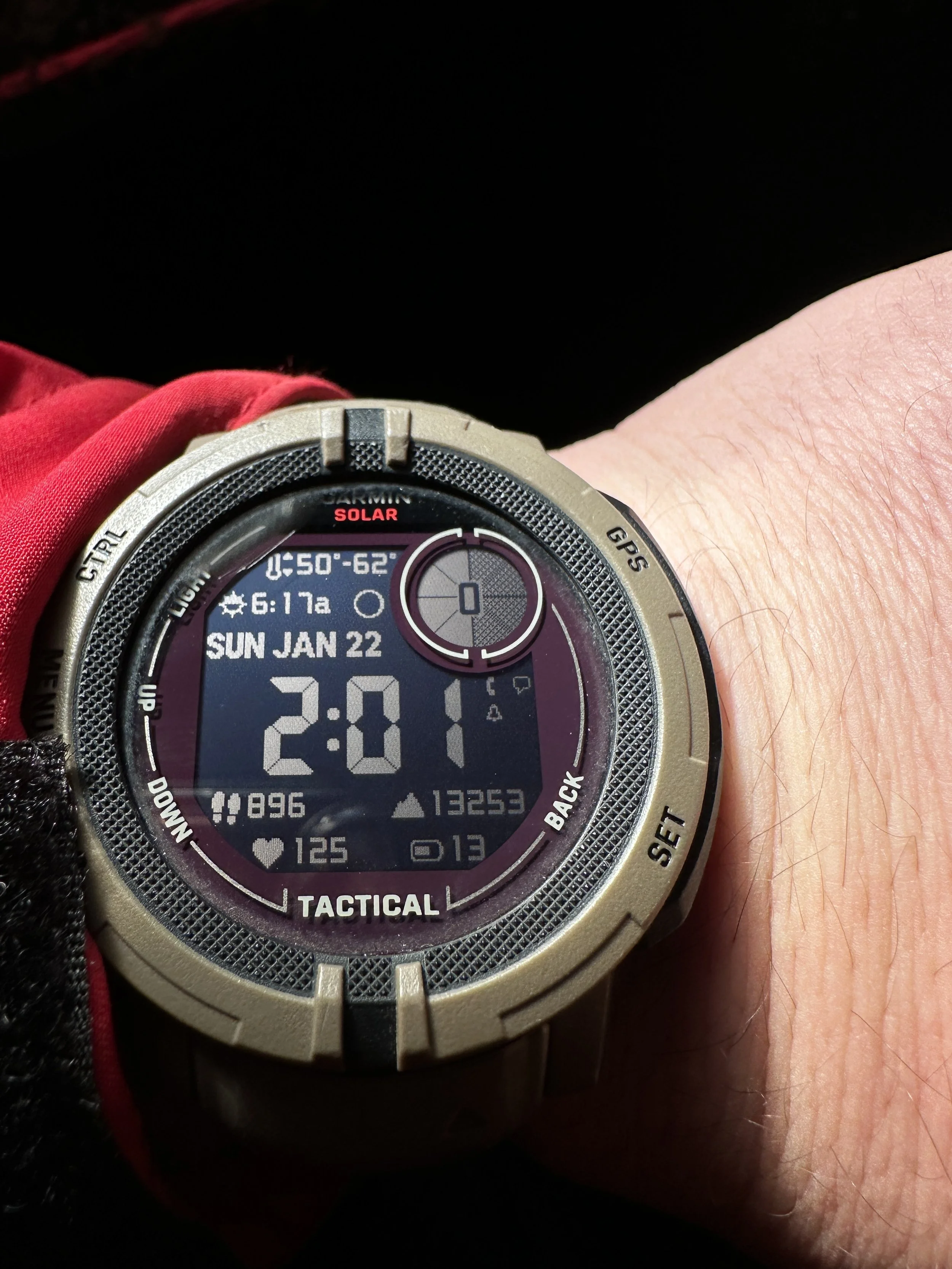 Digital wristwatch displaying the time 2:01, date Sunday, January 22, and other data including battery and step count, worn on a person's wrist.