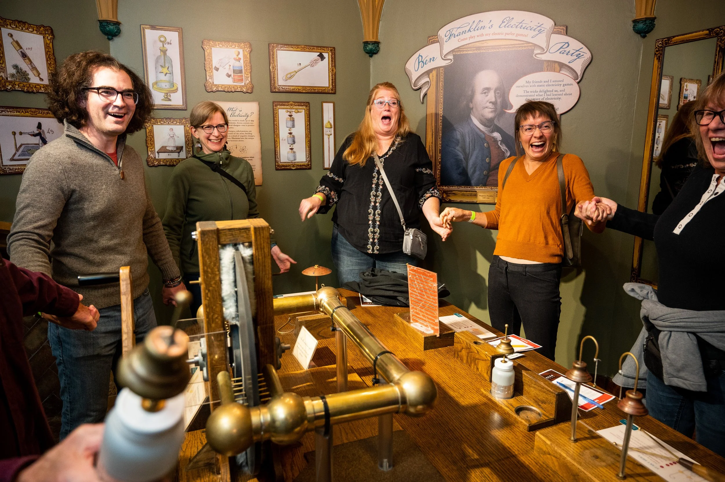 group of adults having fun at the Ben Franklin's Electricity Party Exhibit at The Bakken Museum in Minneapolis
