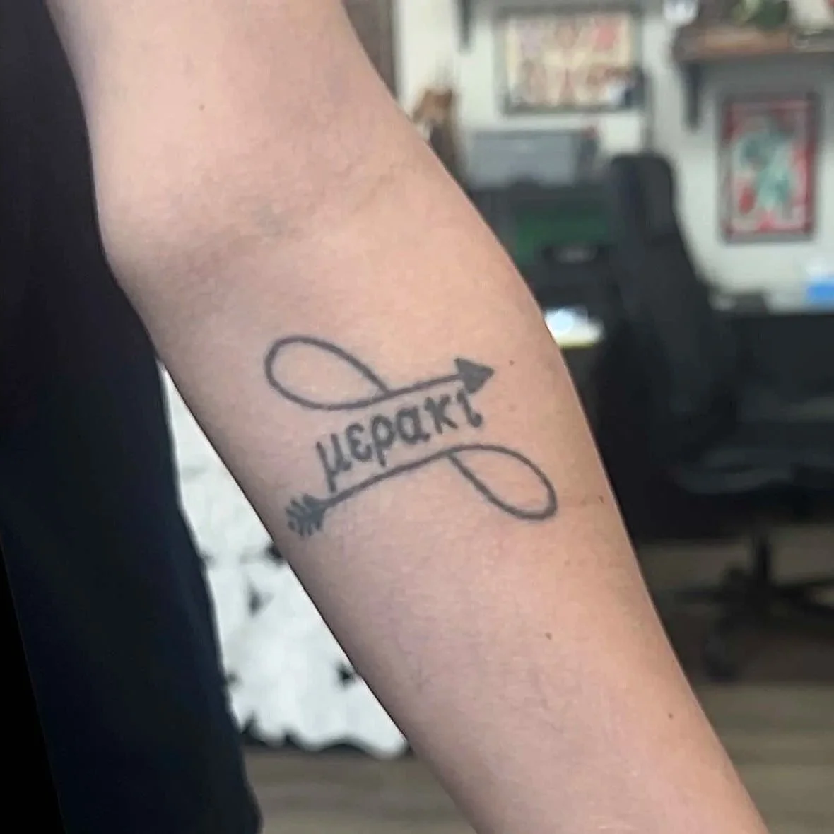 Before: Old script tattoo on forearm, pre-cover-up