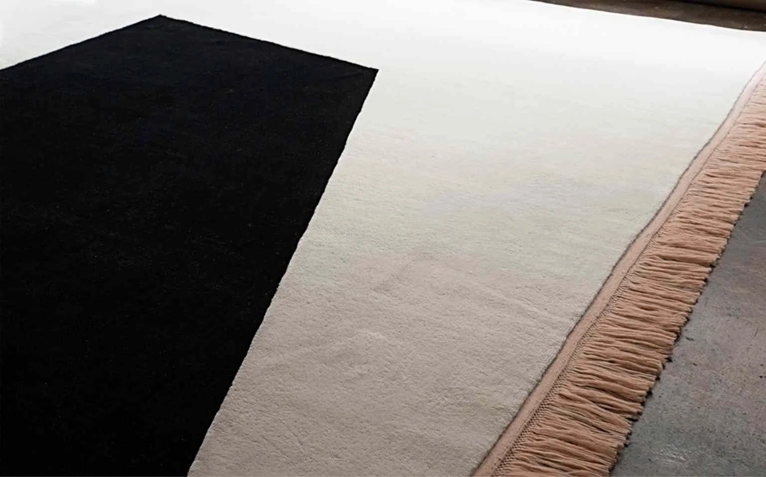 Detailed view of a bespoke rug edge, showcasing the intricate craftsmanship and texture, exemplifying the union of traditional craft and modern design.