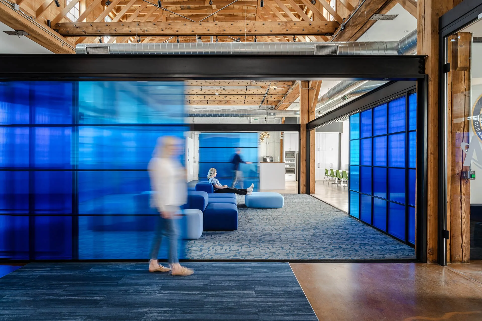 Operable blue polycarbonate screen system fabricated by Raw Creative, featuring sliding and pivoting panels for adaptable office space planning.