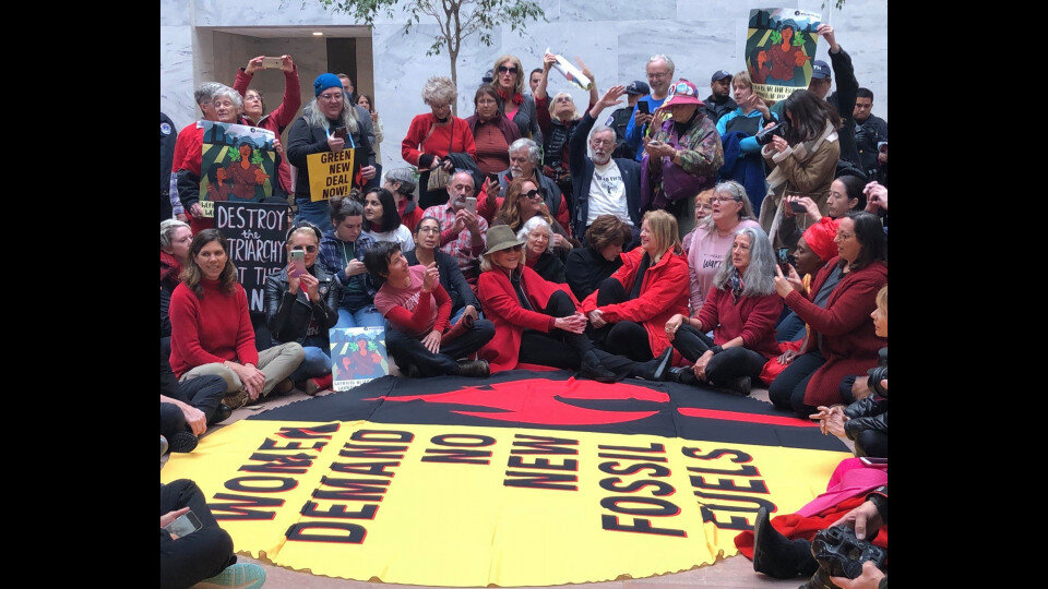 In the Hart Building, protesters chant to demand no new fossil fuel investments and show support for the Green New Deal.
